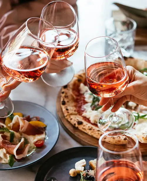 Traditional Italian food featuring pasta, pizza, fresh herbs, and rustic Mediterranean ingredients served on a dining table.