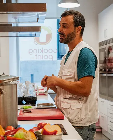 A chef instructor demonstrating a recipe to students at a cooking class in Madrid