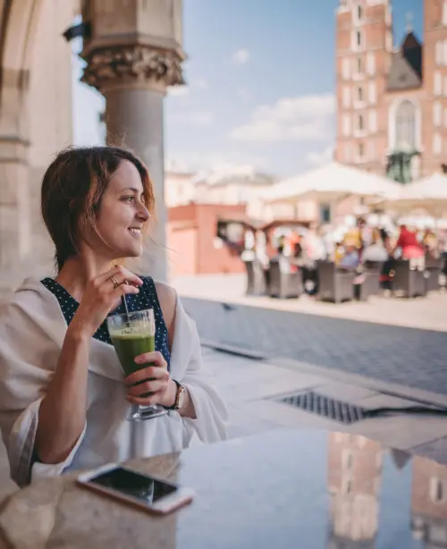Tourist sitting in a café in Kraków, enjoying coffee with a view of historic streets and cobblestone surroundings
