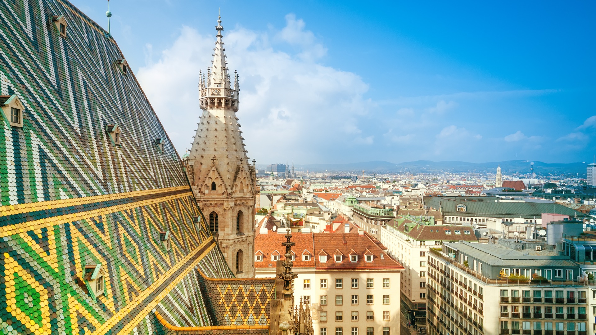 A panoramic view of Vienna's skyline with St. Stephen's roof on the foreground. 