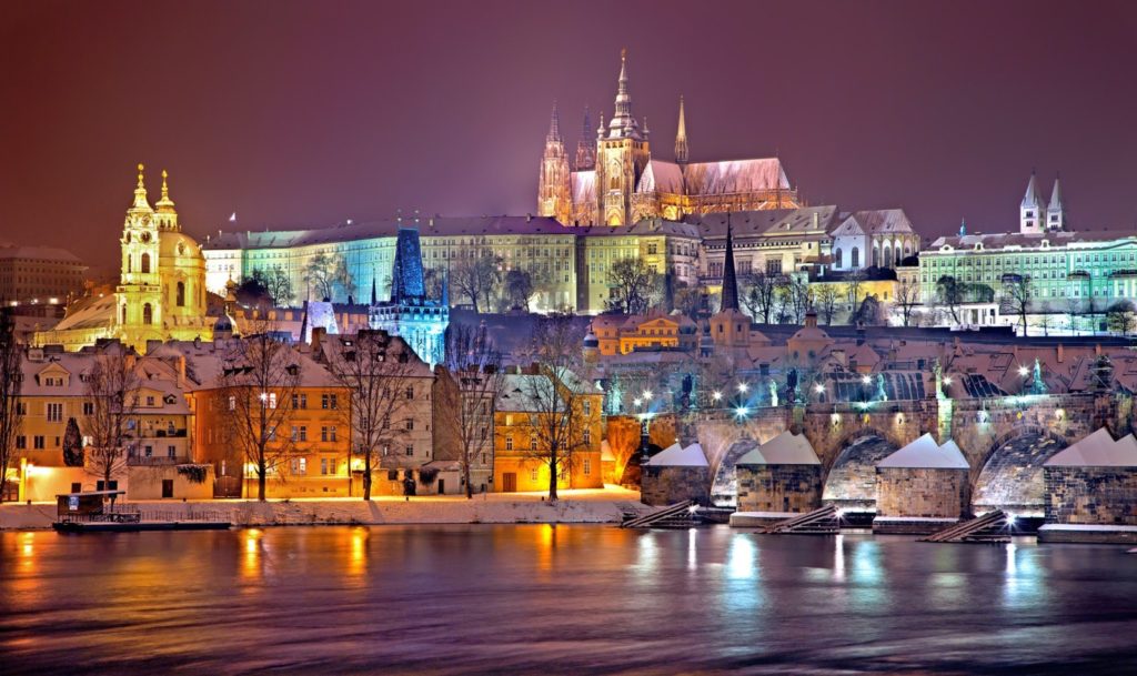 Charles Bridge and Prague Castle with a dusting of snow, at night.