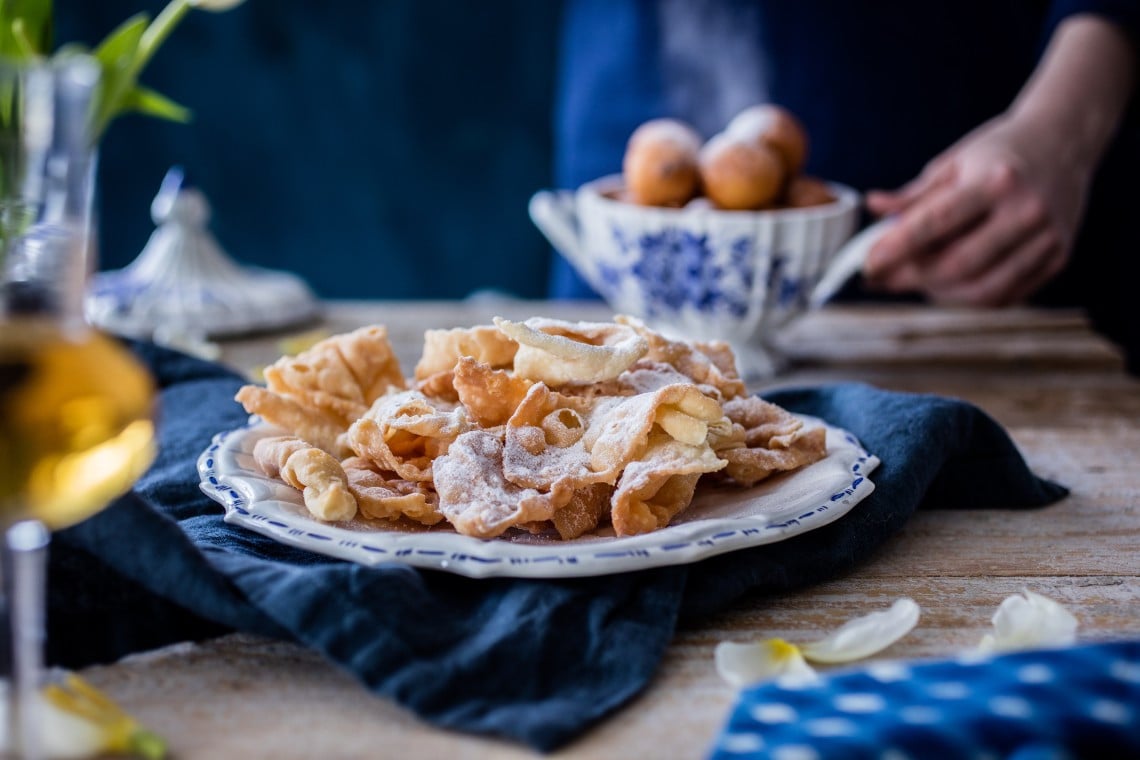 A plate of Krostule with other sweets in the background. 