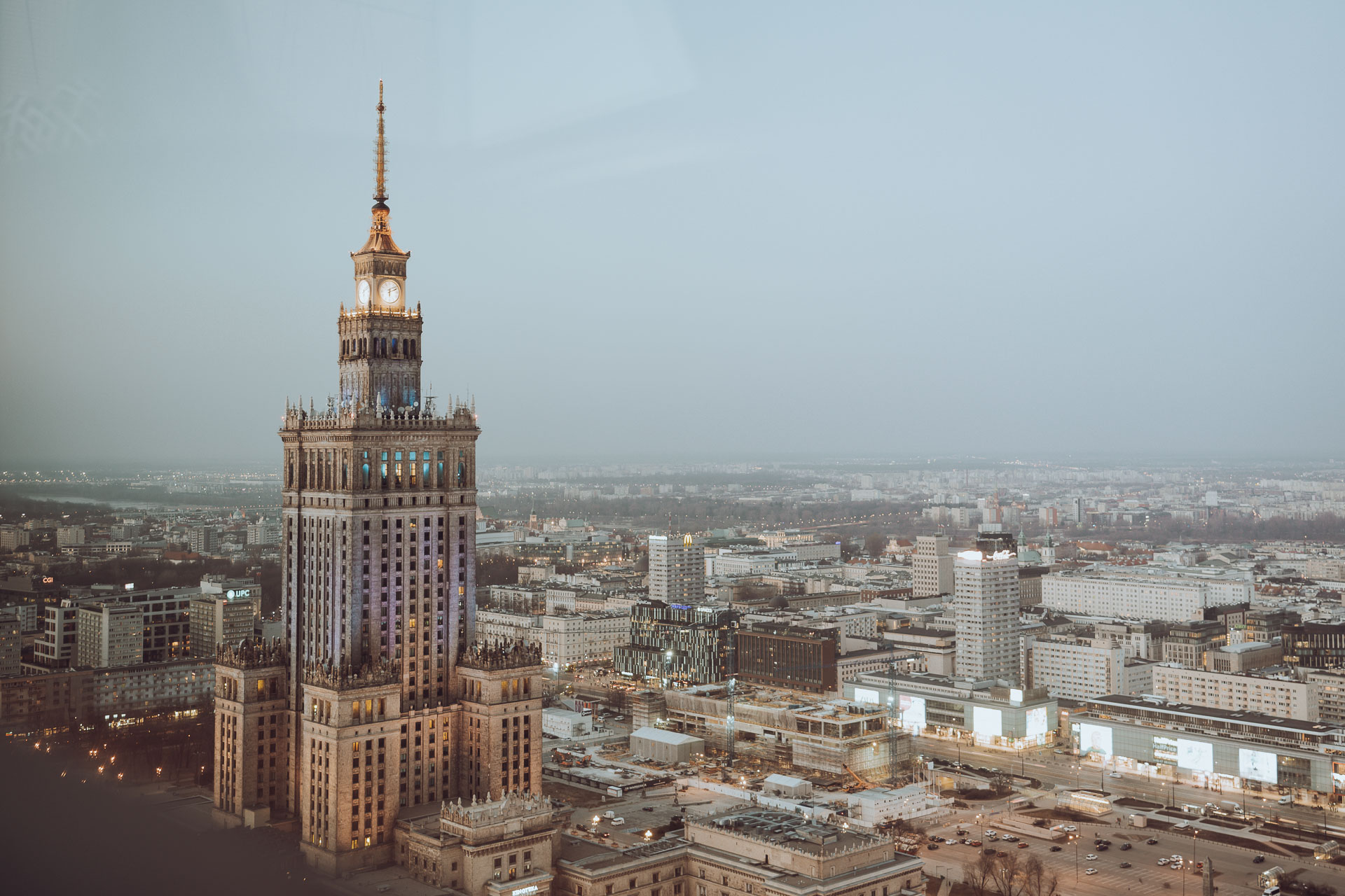 The view from the Panorama Sky Bar of the Marriott Hotel is one of the best views in Warsaw, Poland. We see the Palace of Culture and Science at dawn, lighting up with blue and yellow as a solidarity gesture toward Ukrainians.