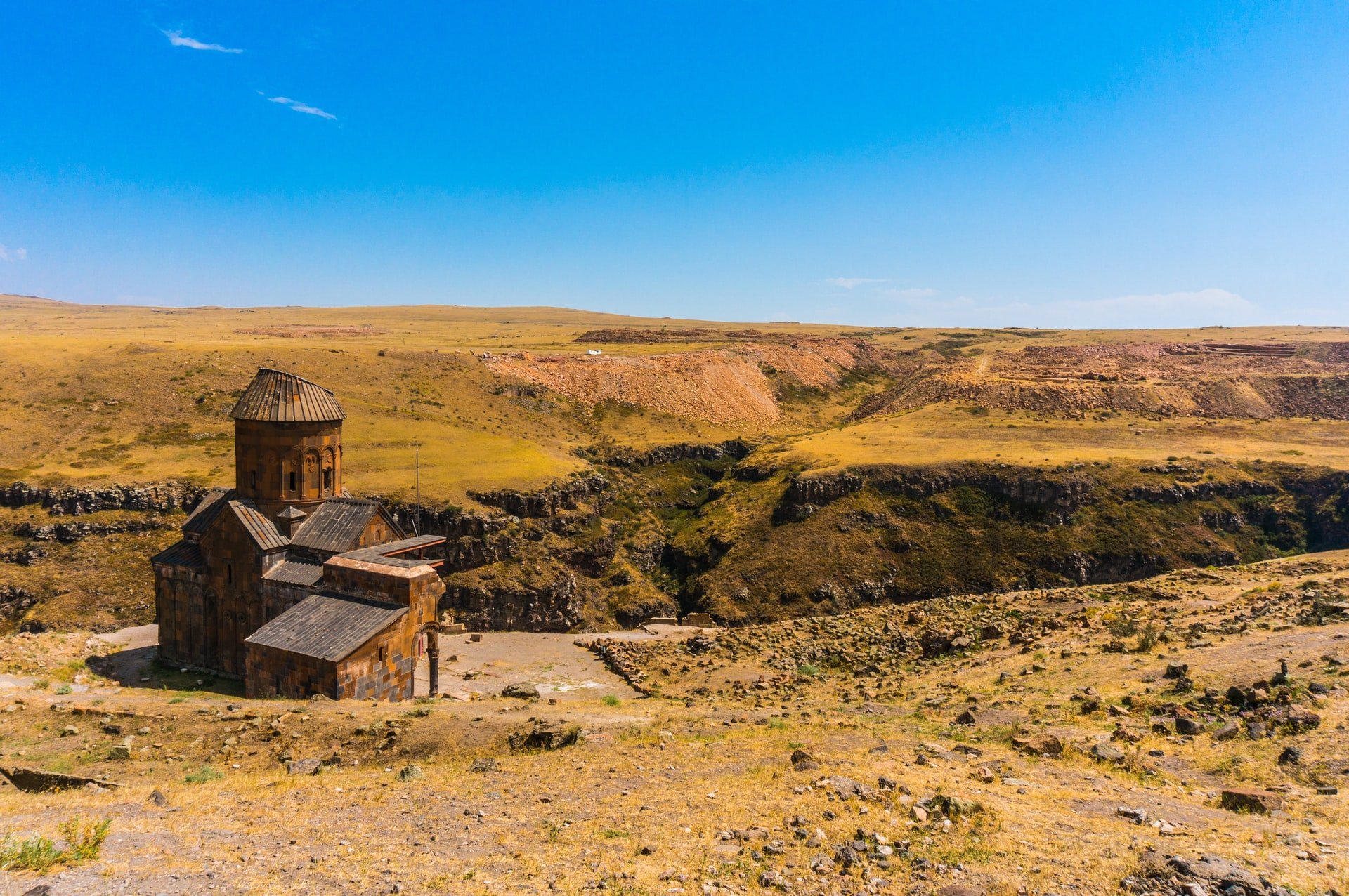 Cette image montre une ancienne église située dans un paysage d'une beauté brute.