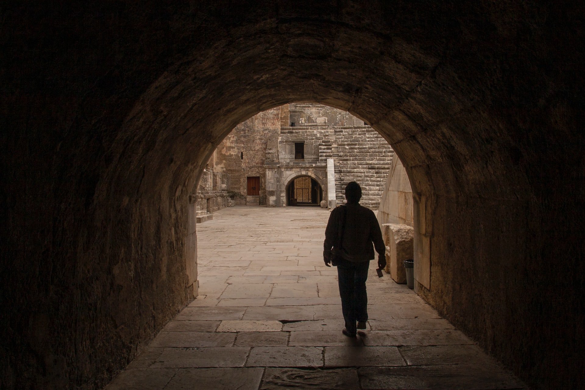 This image shows a man walking under an arched passageway in Aspendos theater.