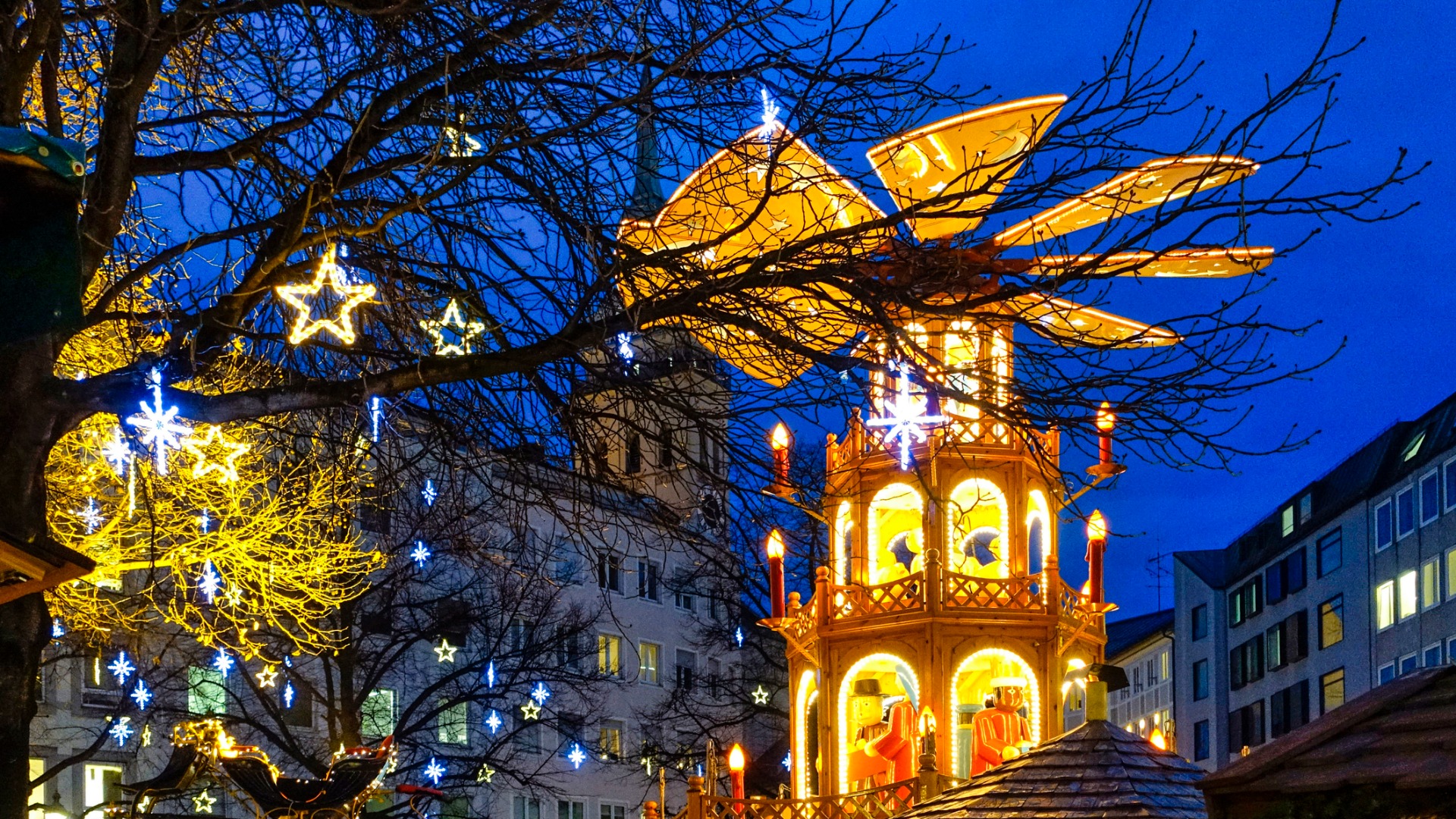 Această imagine prezintă un carusel din lemn la o piață de Crăciun din München. 