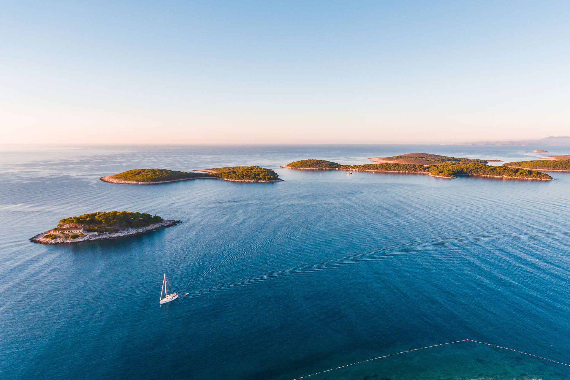 This is a drone shot of tiny islands dotting the sea. 