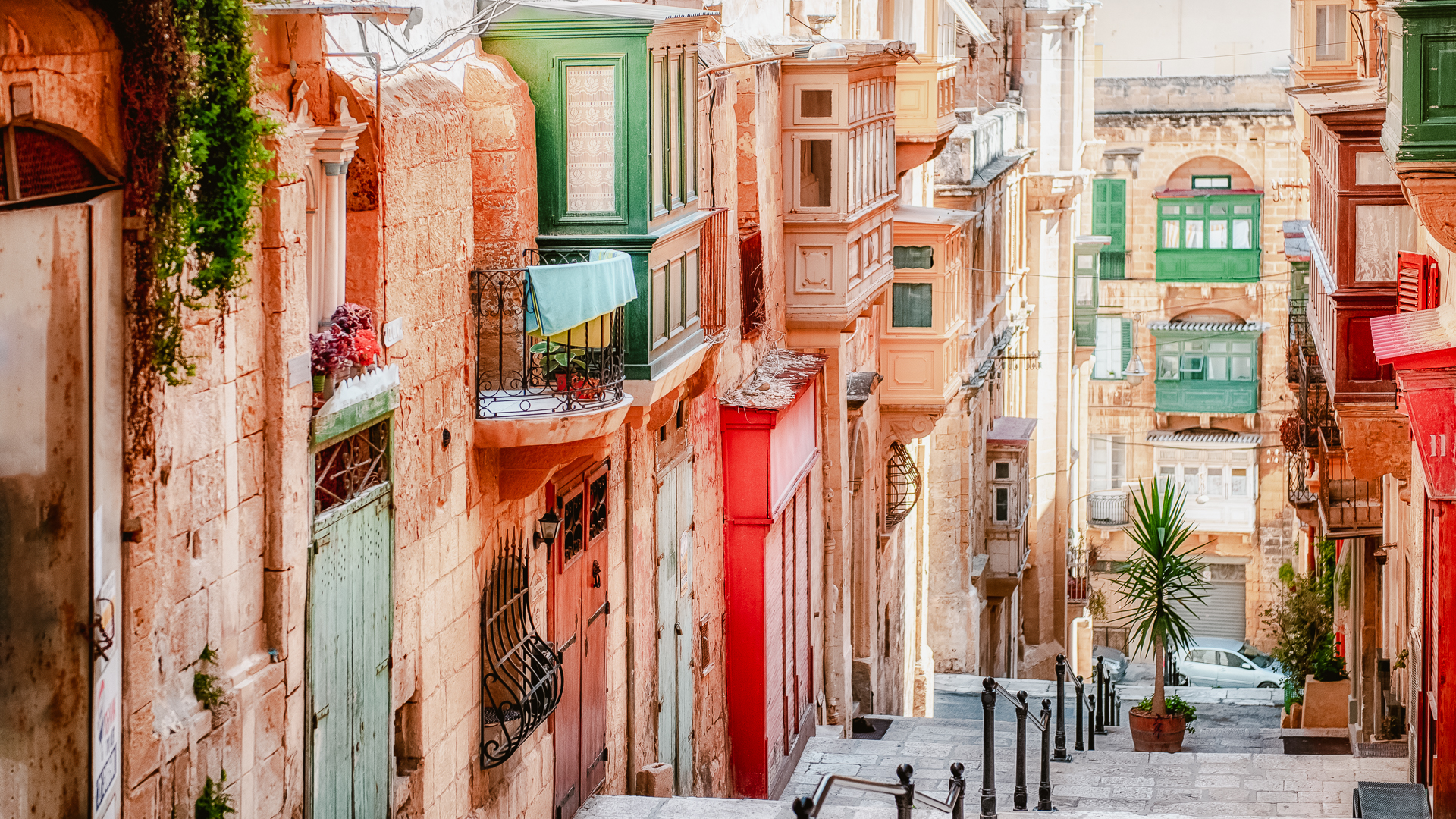 Narrow street in Valletta - the capital of Malta - with colorful doors stacked up all the way down.