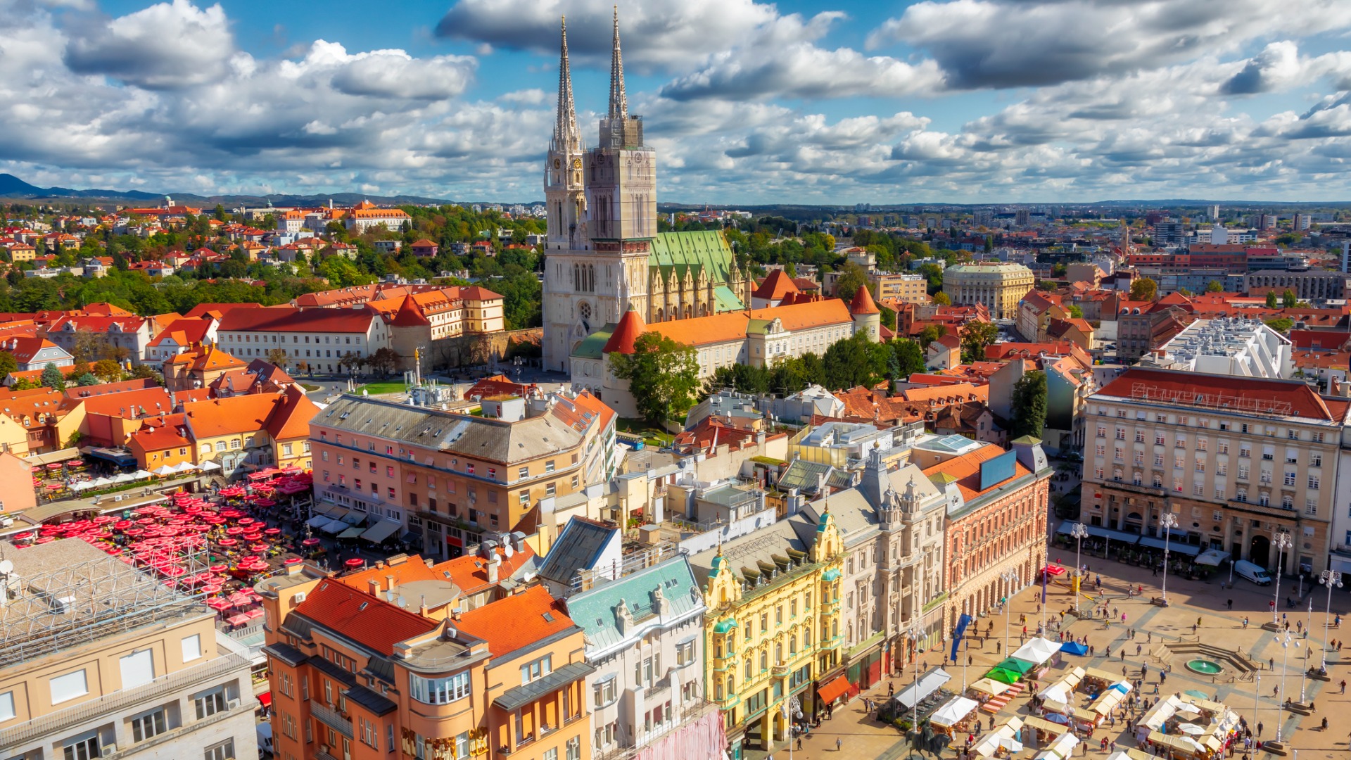 Esta é uma vista panorâmica de Zagreb sob um céu ensolarado pontilhado por belas nuvens. 