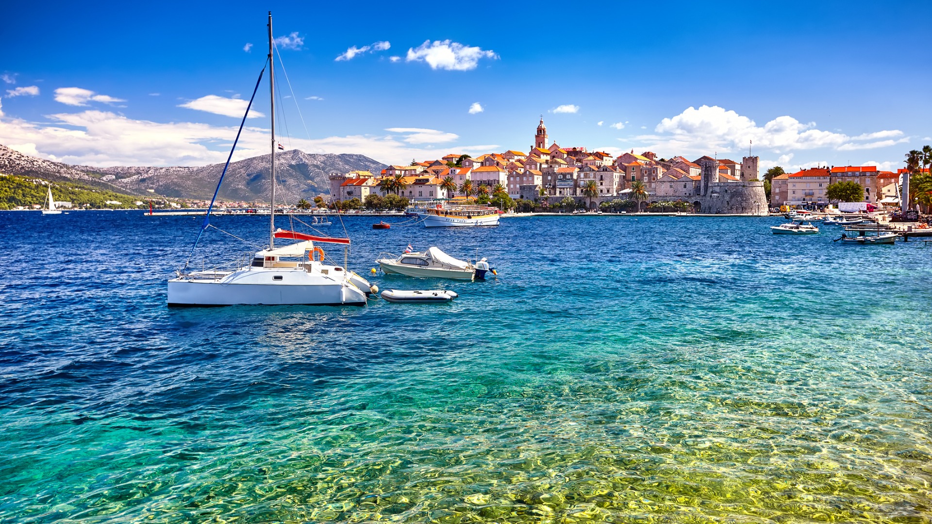 This image shows the turquoise waters of Korcula with the Old Town in the background.