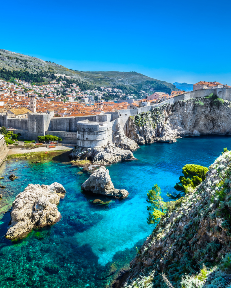 The walls of Dubrovnik taken from Fort Lovrenac, with bright turquoise sea in the foreground.