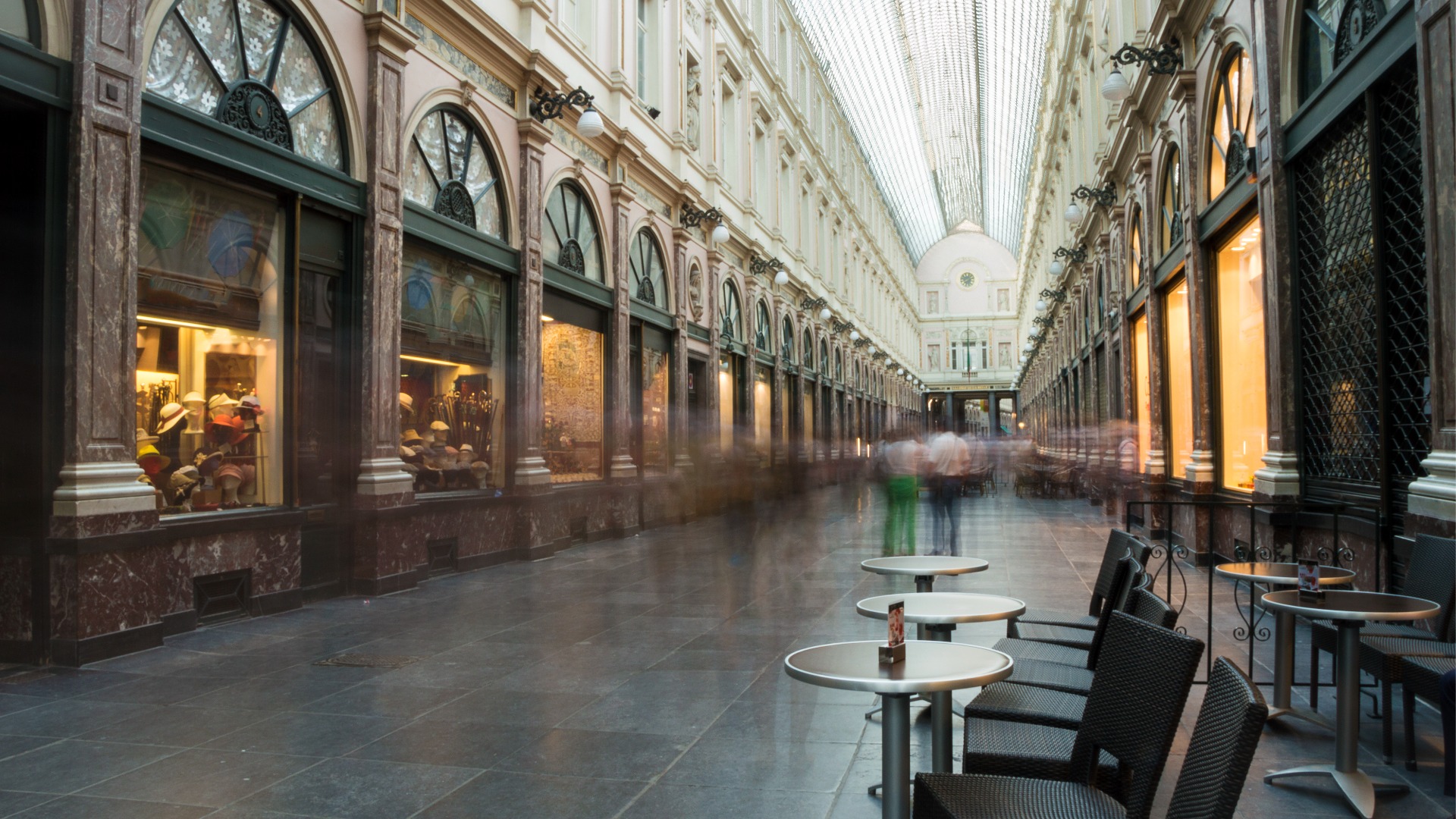 This images shows a corridor inside Galeries Royal Saint Hubert with a glass roof over it. 