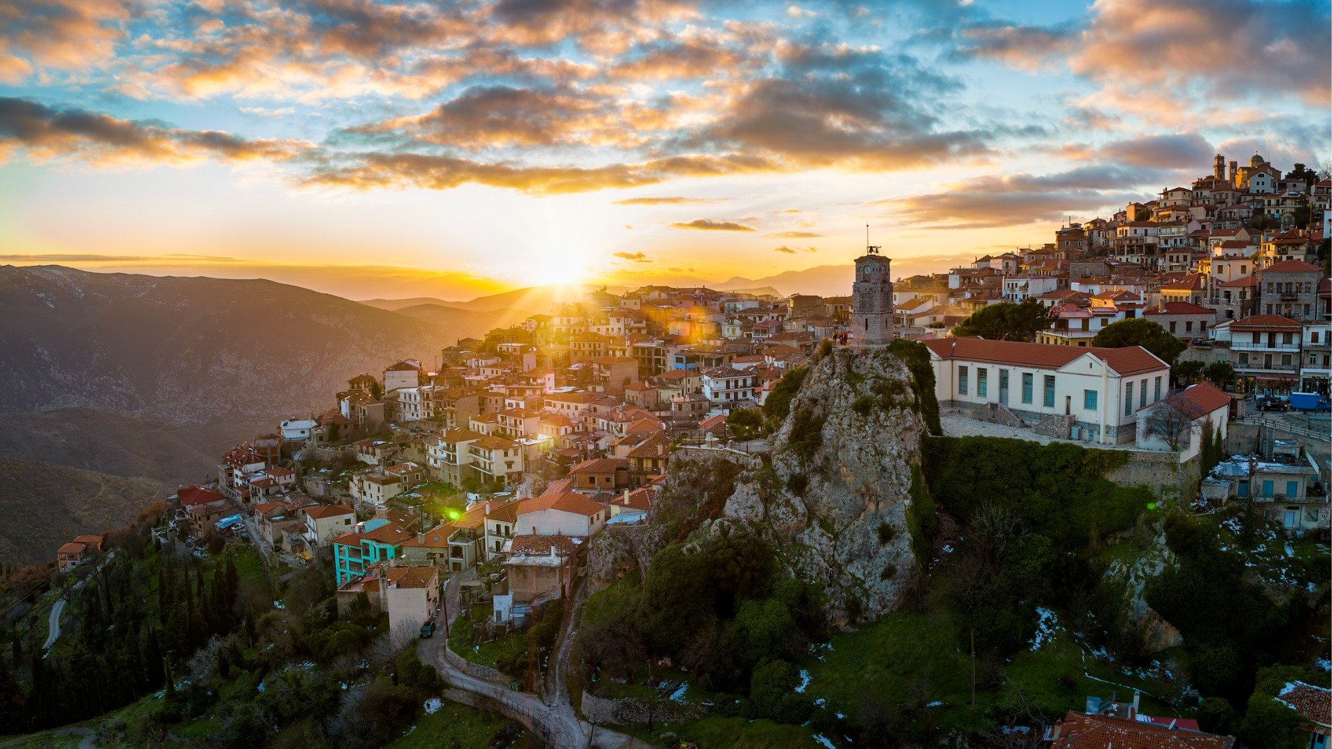 This image shows the sun setting over Arachova and its red-tiled roofs. 