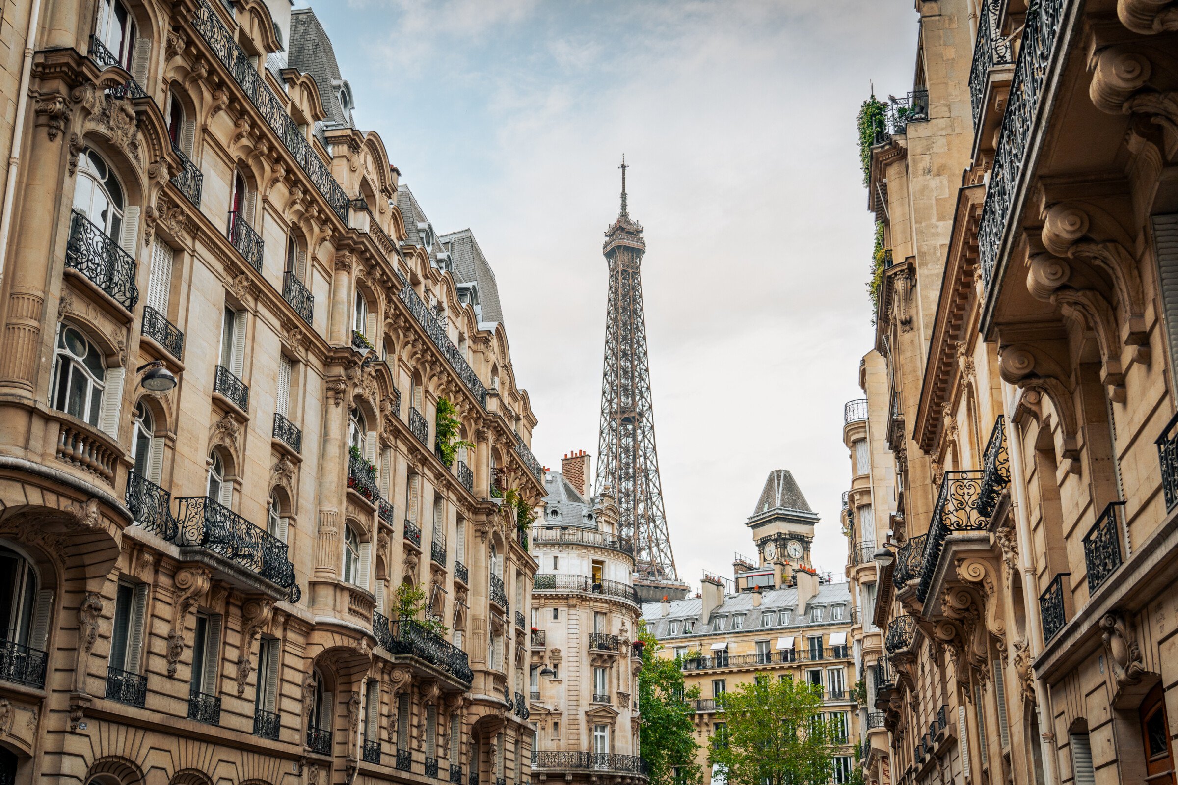 This image shows the top part of the Eiffel Tower in the background with some typically Parisian buildings in the foreground. 