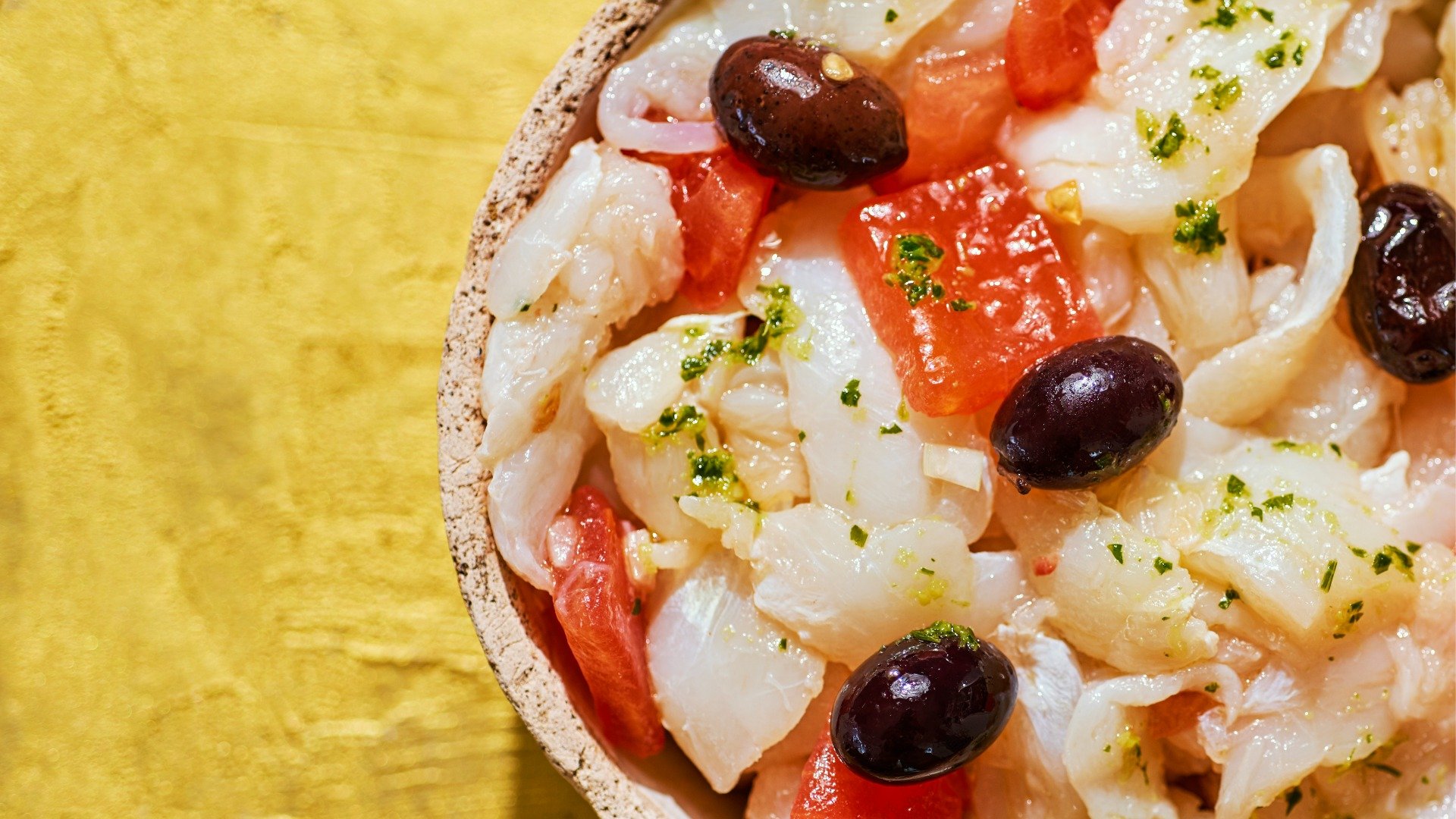 This is a close-up of Esqueixada, cod, tomatoes, and black olives. 