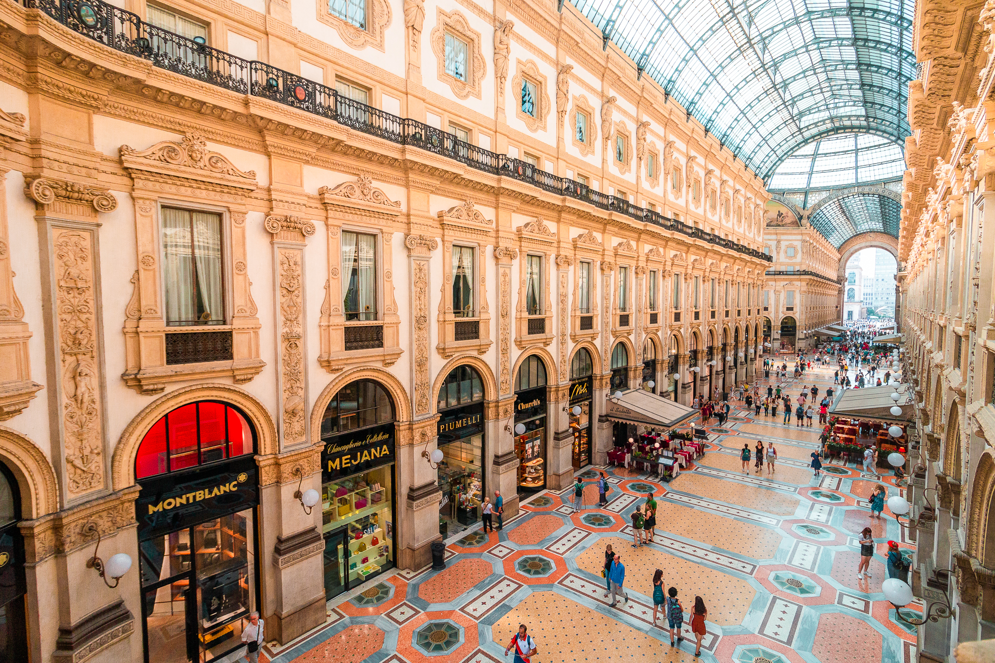 This is a panoramic view of the interior of Galleria Vittorio Emanuele II in Milan, one of the best places to visit in Italy. 