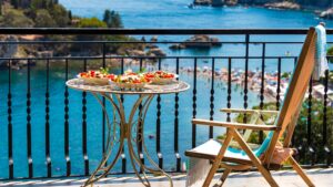 This image shows a table with three dishes of Italian food. In the background, beautiful sea views.