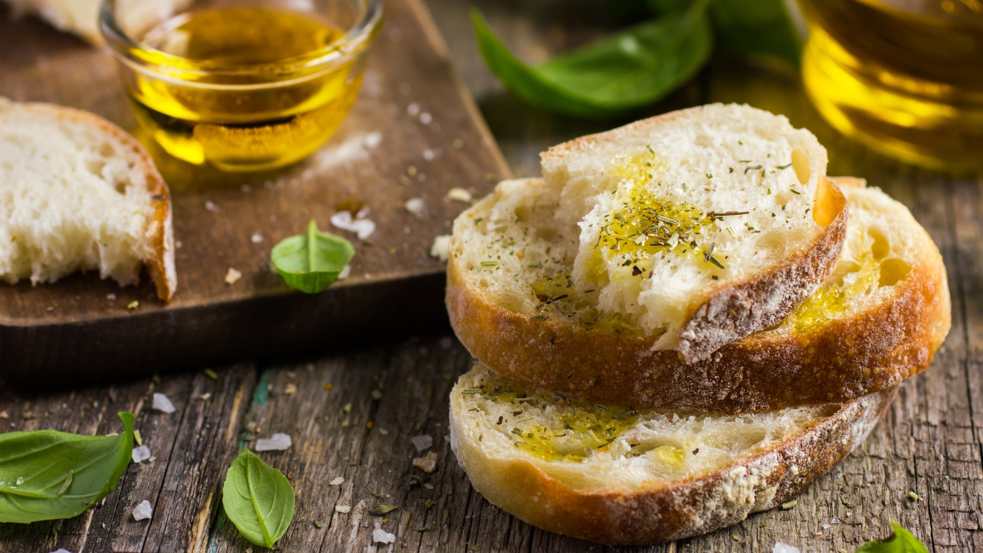 This is a close up of slices of bread with olive oil and herbs. 