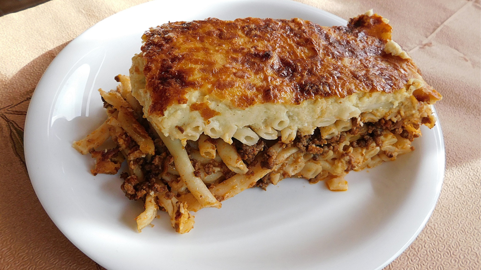 A close up of a large piece of Pastitsio, a staple of any best Greek food list. 