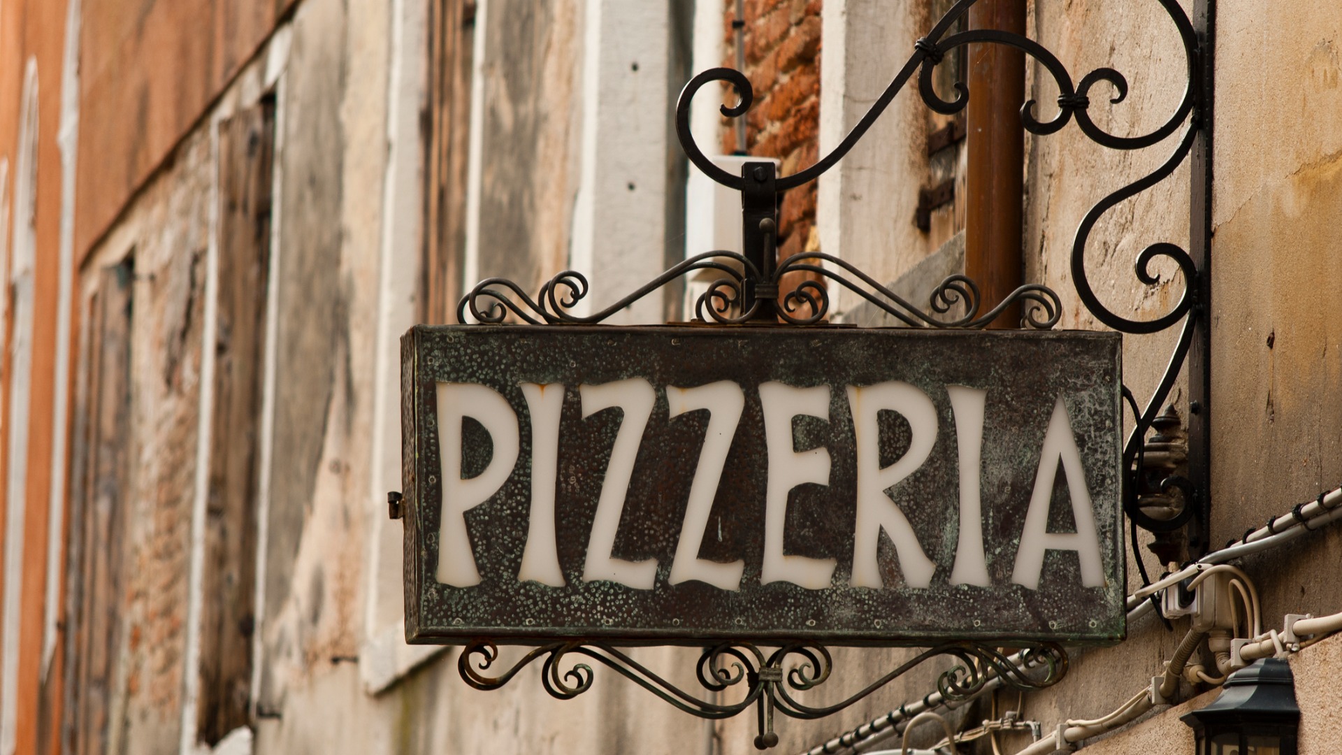 A close up of a Pizzeria iron cast sign. 
