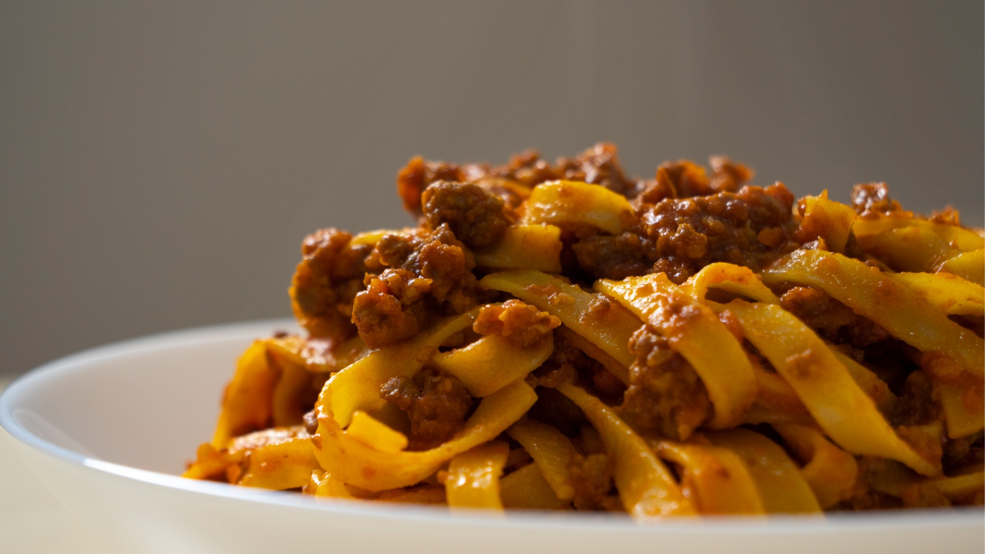 A close up of a dish filled with tagliatelle al ragu, a staple of Italian cuisine. 