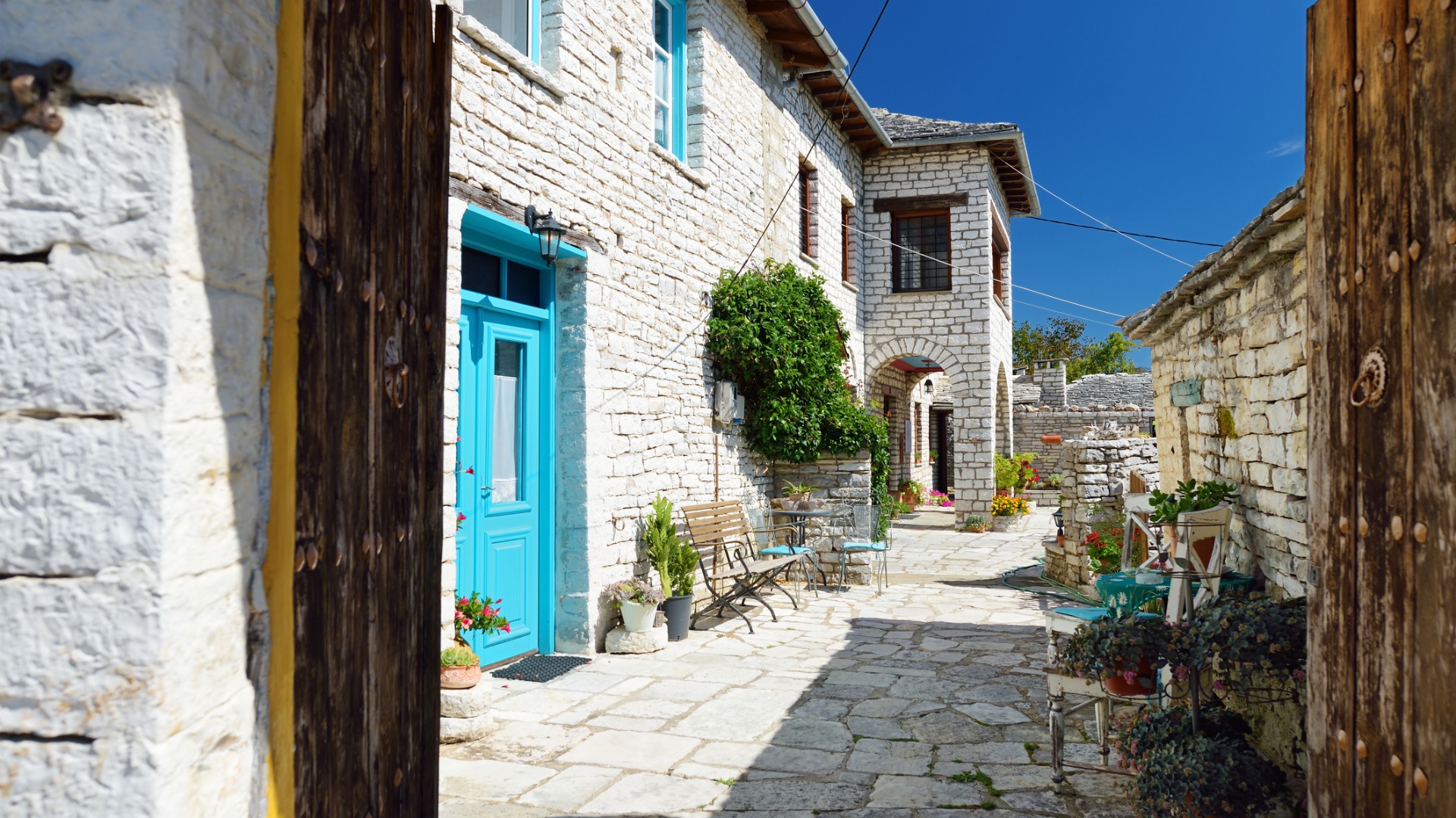 Traditional stone-made buildings and stone walkway in Monodendri village in the summer, the best time to visit Greece, and more specifically the mountain region of Epirus.