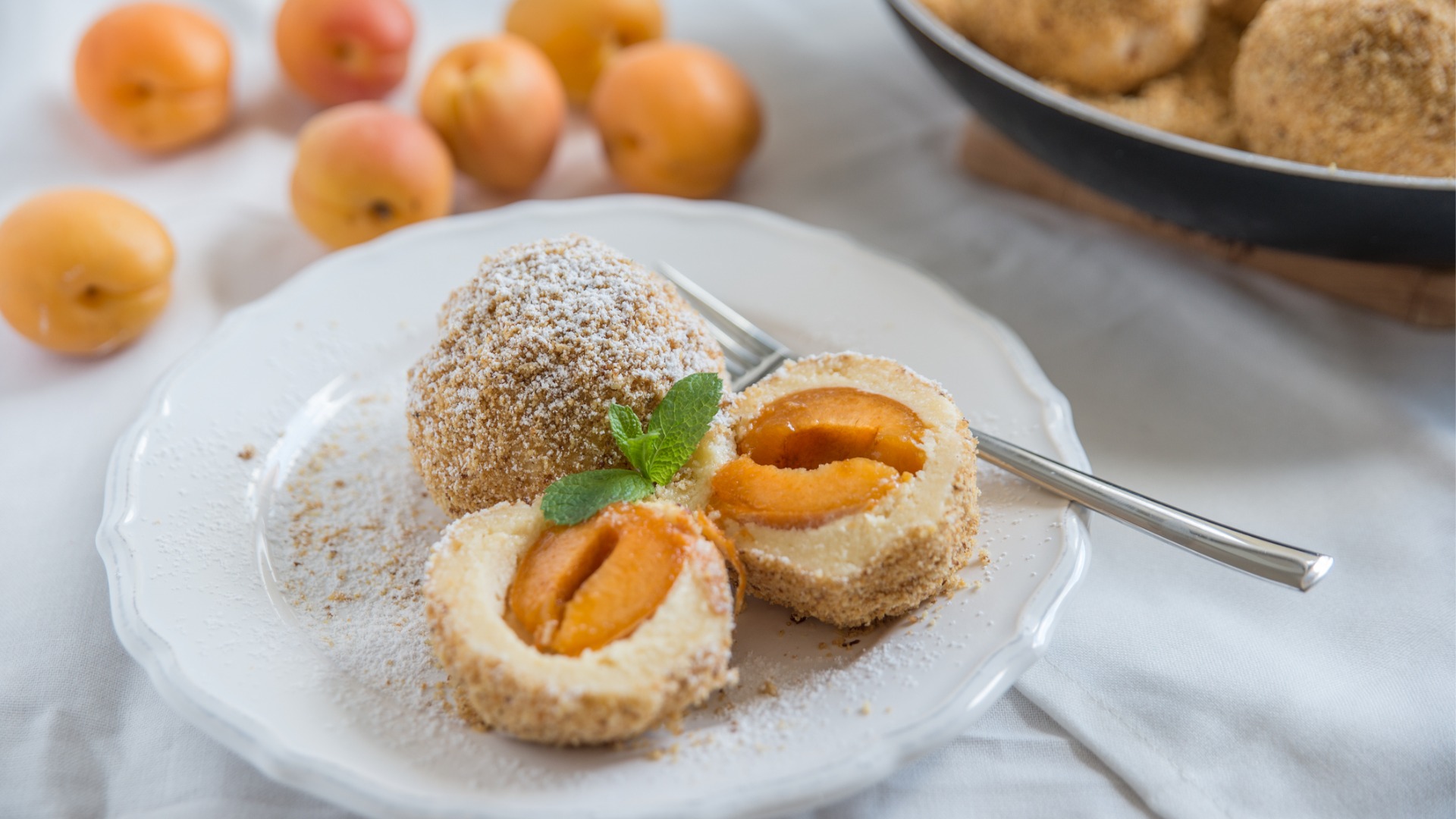 A plate with two Marillenknodel, sweet dumplings filled with cored halves of apricots.