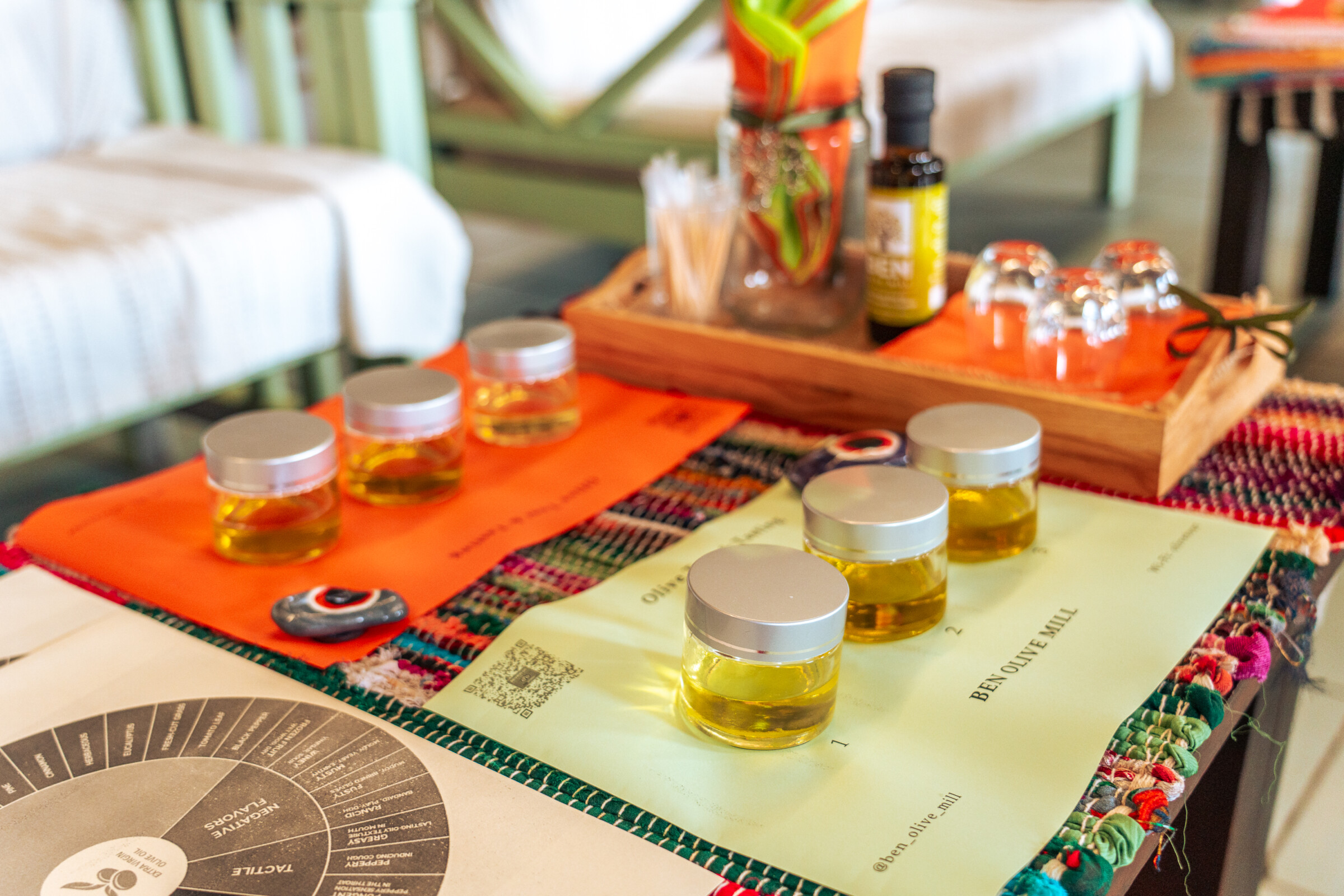 Two rows of three small jars with olive oil, set up for an olive oil tasting. 