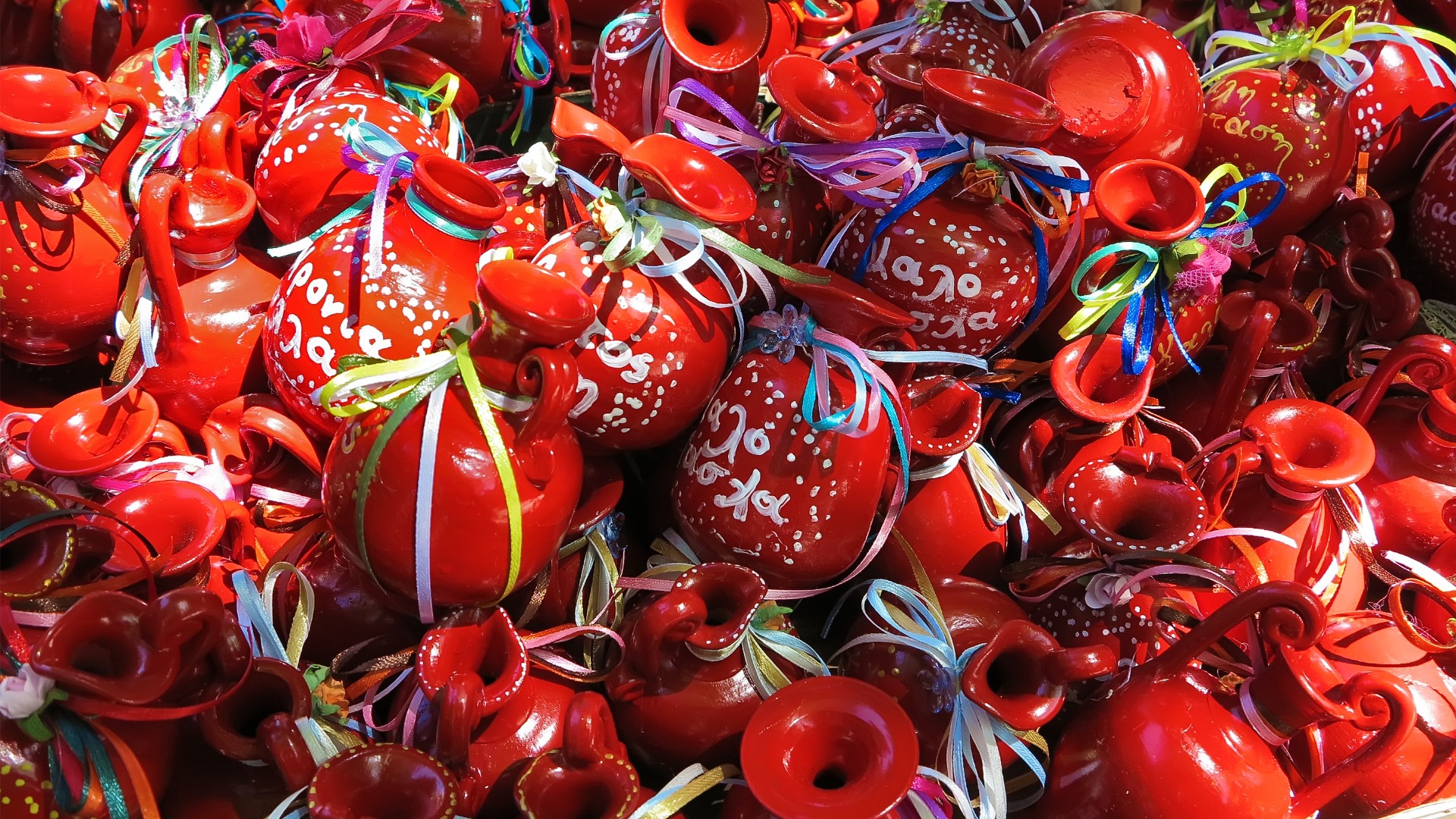 Several red clay pots adorned with colorful ribbons. 