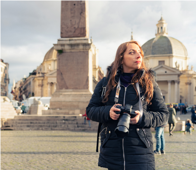 Woman with camera standing in a square in Italy