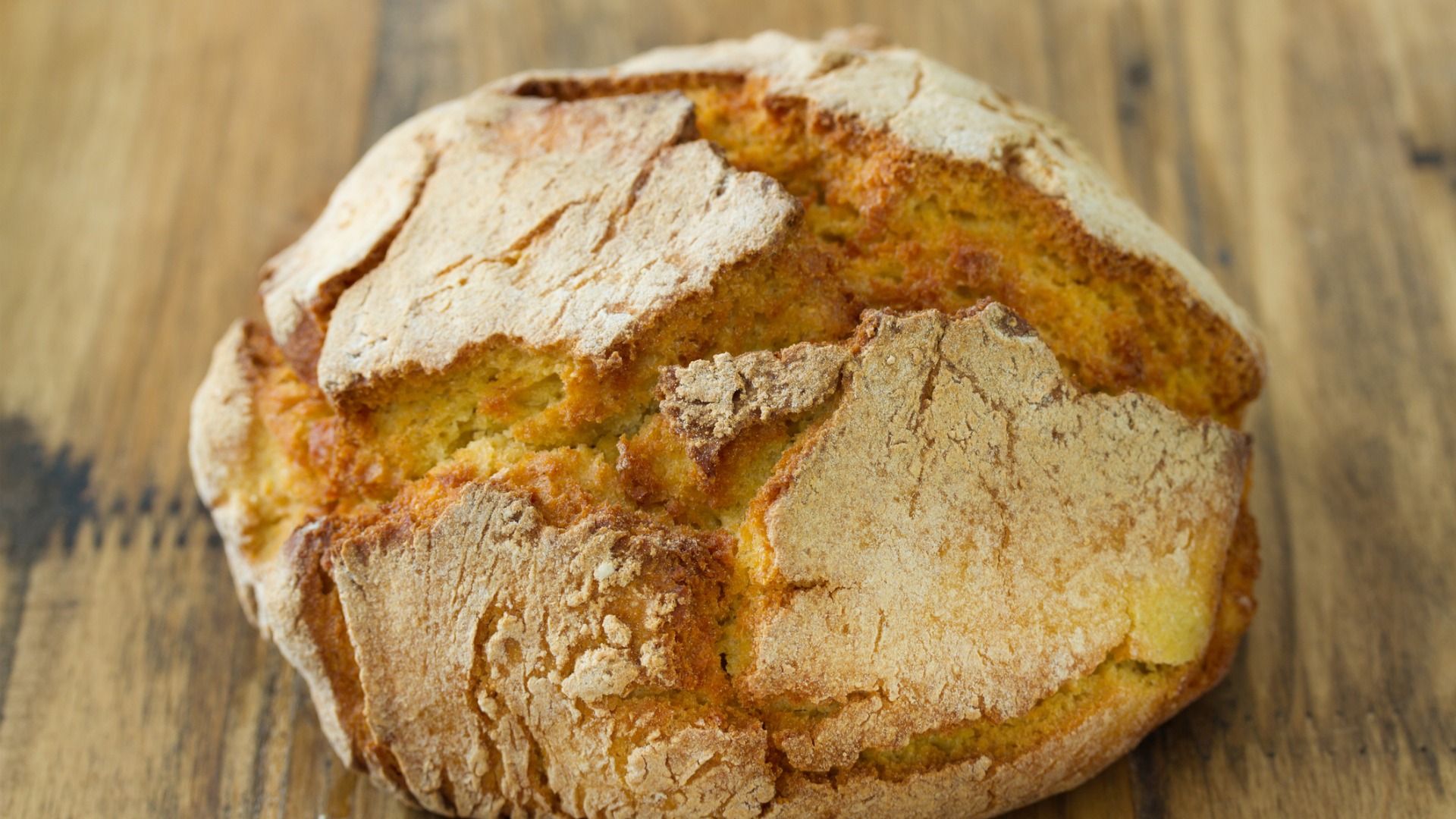 A close up of a freshly baked round loaf of cornbread. 