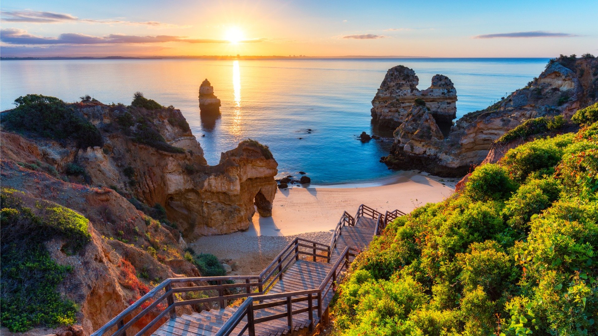 A beautiful cove surrounded by dramatic rocks with a footbridge in the foreground. 