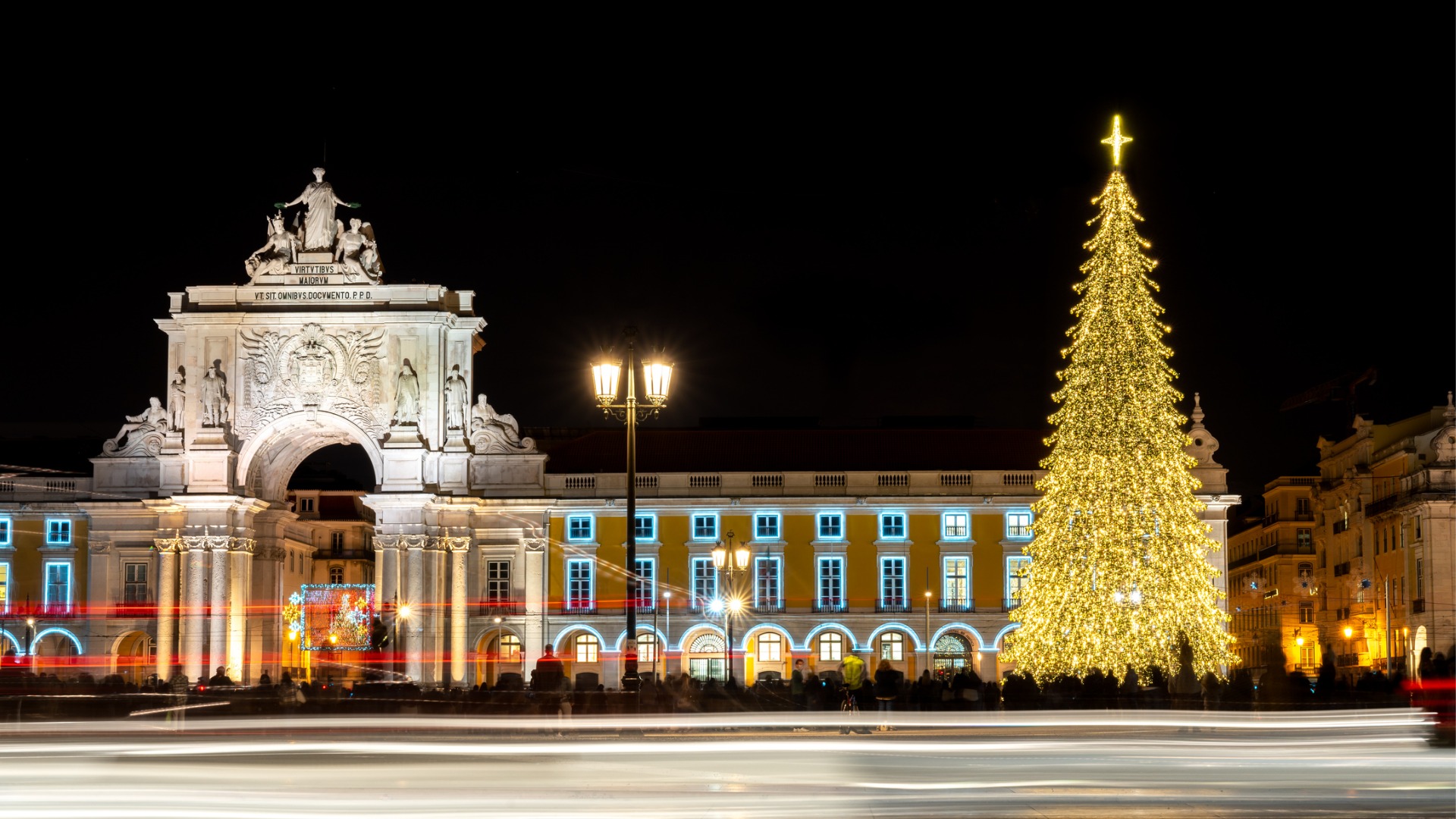 The illuminated Rua Augusta Arch and a tall Christmas tree to its right. Early December is the best time to visit Portugal for laid-back festive cheer. 