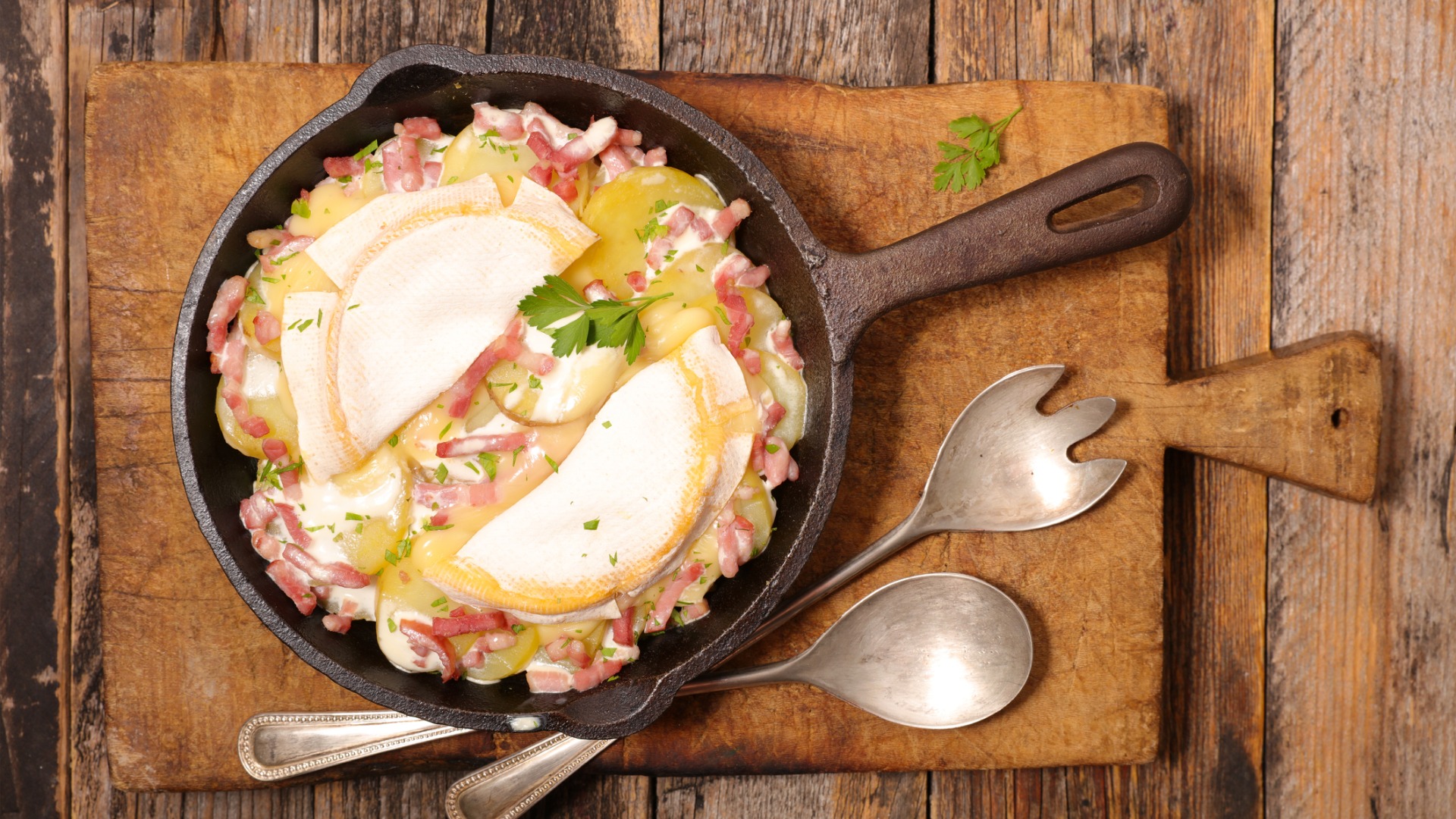 A top down of a cast-iron skillet with Tartiflette, one of the best French dishes. 