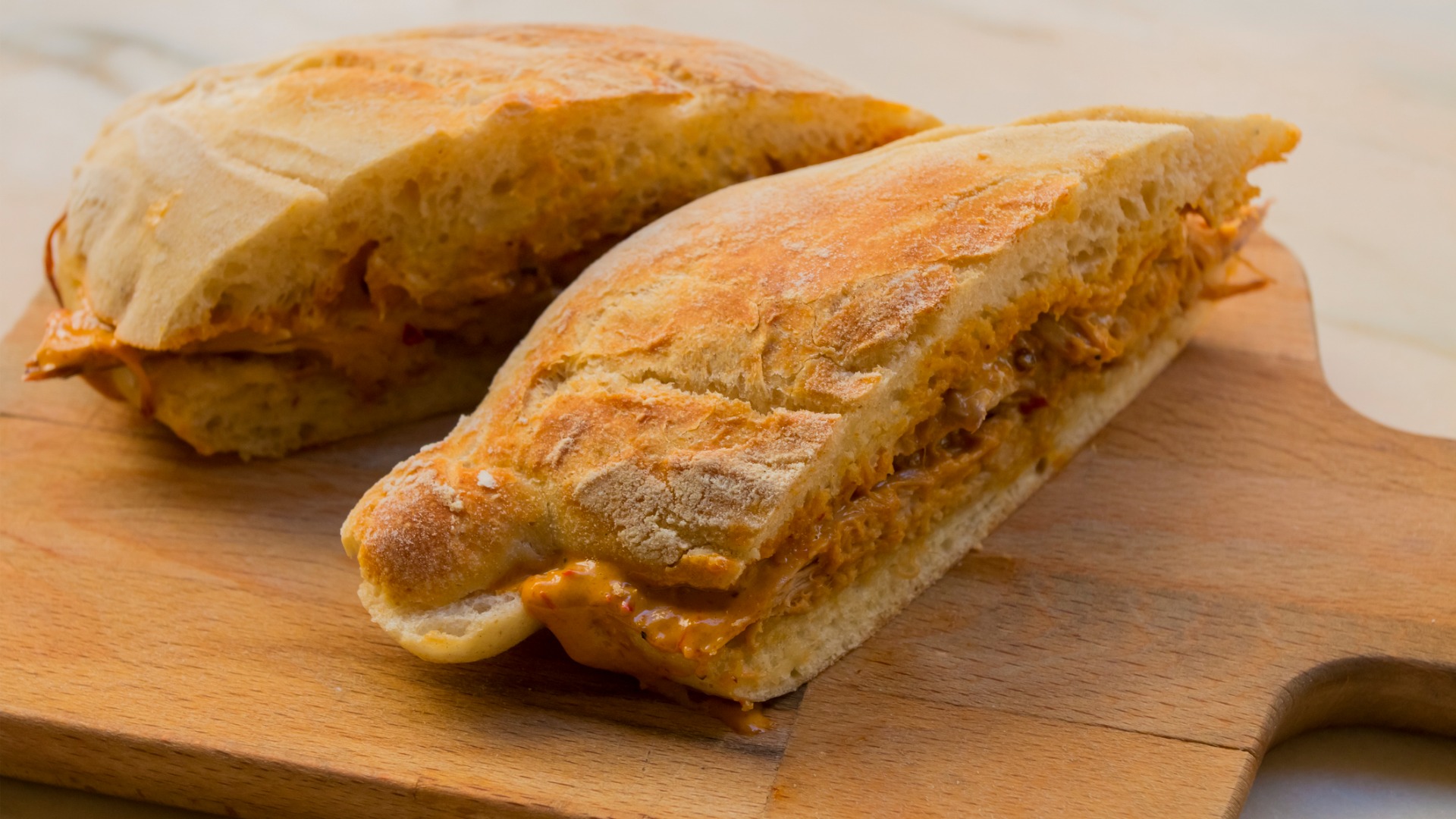 A close up of two pieces of bread filled with meat. 