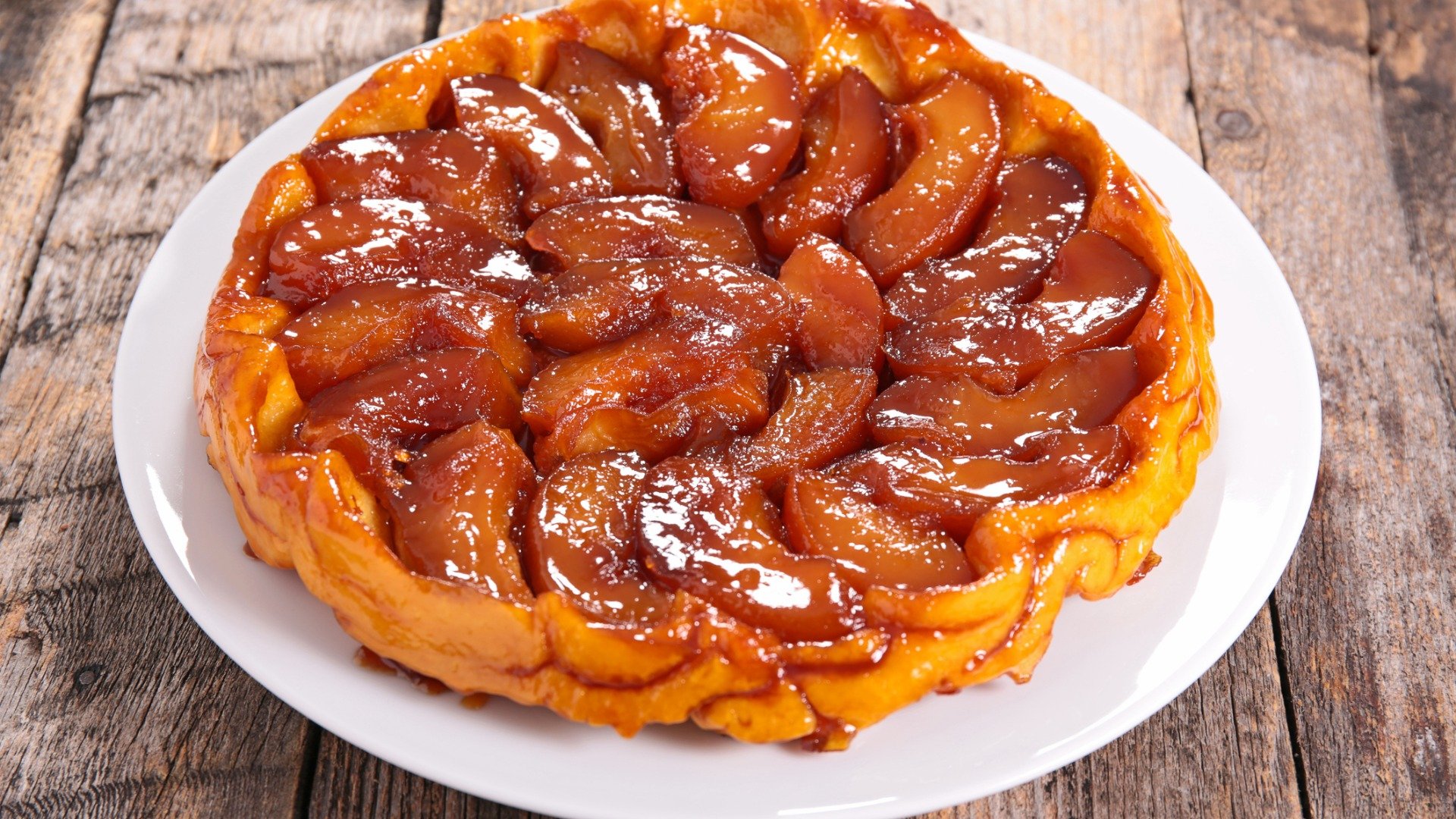 A close up of a Tarte Tatin topped with caramelized apple slices. 