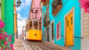 The iconic yellow tram of Lisbon and colorful buildings.