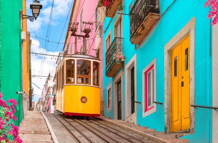 The iconic yellow tram of Lisbon and colorful buildings.