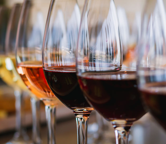 wine glasses containing several varieties of wine in different colors