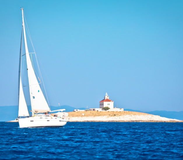 A sailboat in front of a tiny island