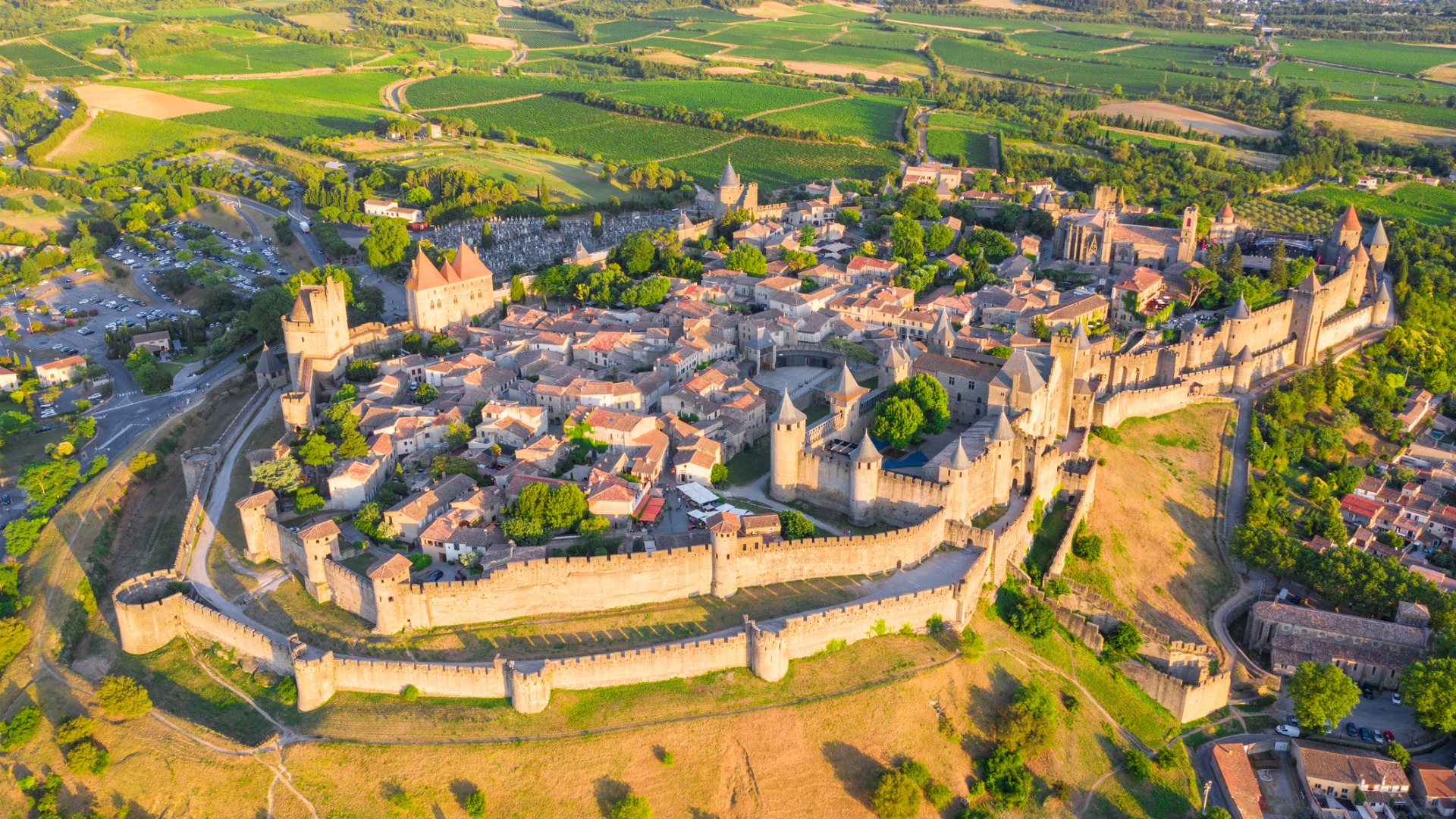 An aerial view of the town of Carcassone, one of the top UNESCO World Heritage Sites in France. The entire town is surrounded by defensive walls and towers. 