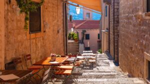 A street in the Old Town of Dubrovnik with tables and chairs.