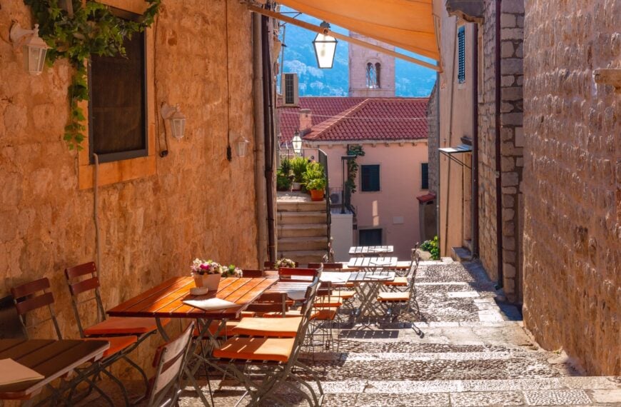 A street in the Old Town of Dubrovnik with tables and chairs.