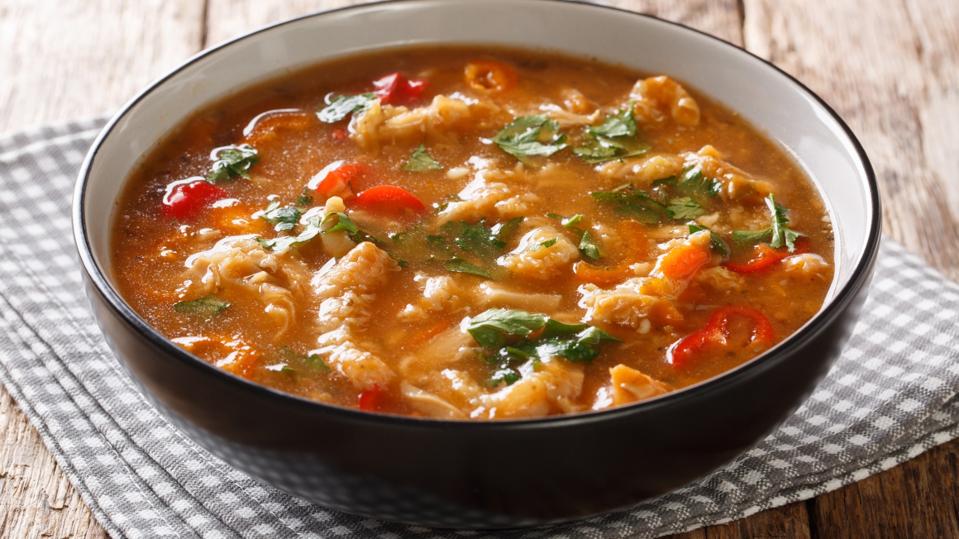 A black and white bowl filled with soup. 