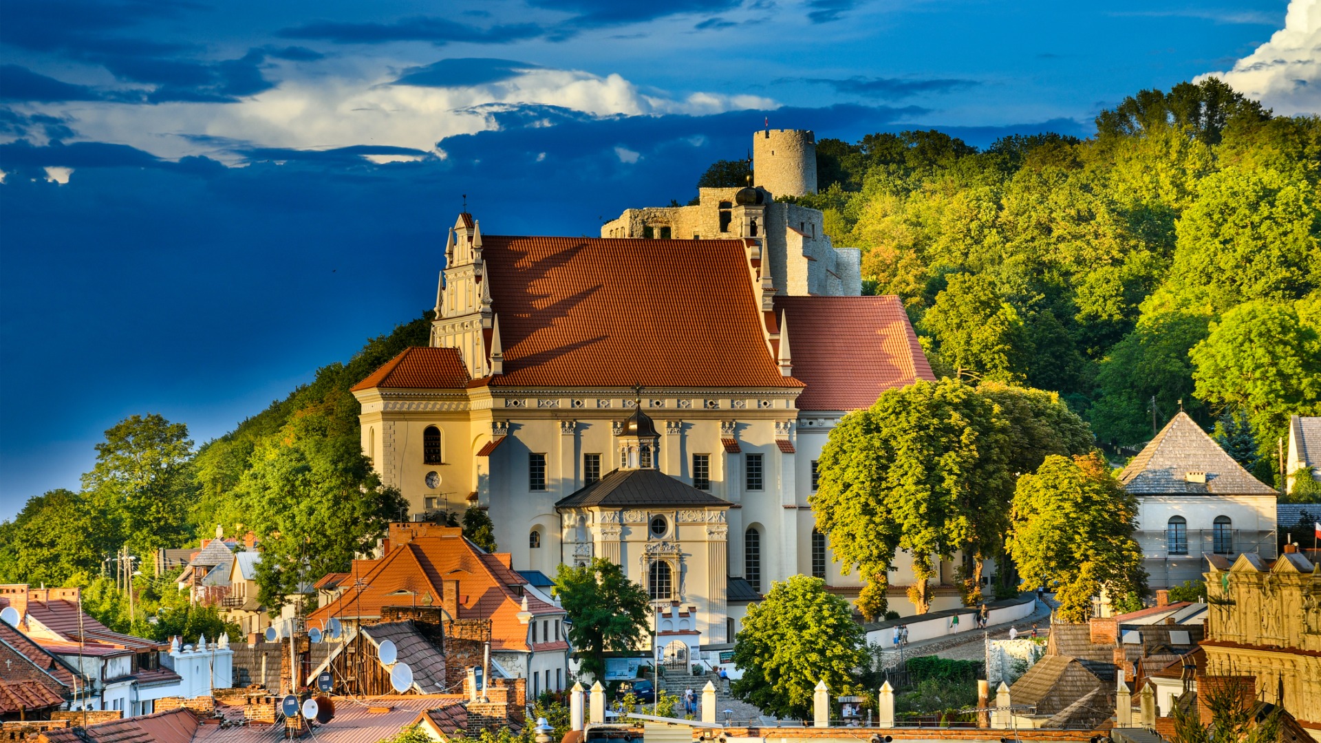 A view of the roofs of the houses and Renaissance Parish Church of St. John the Baptist and St. Bartholomew in Kazimierz Dolny, one of the prettiest places to visit in Poland.