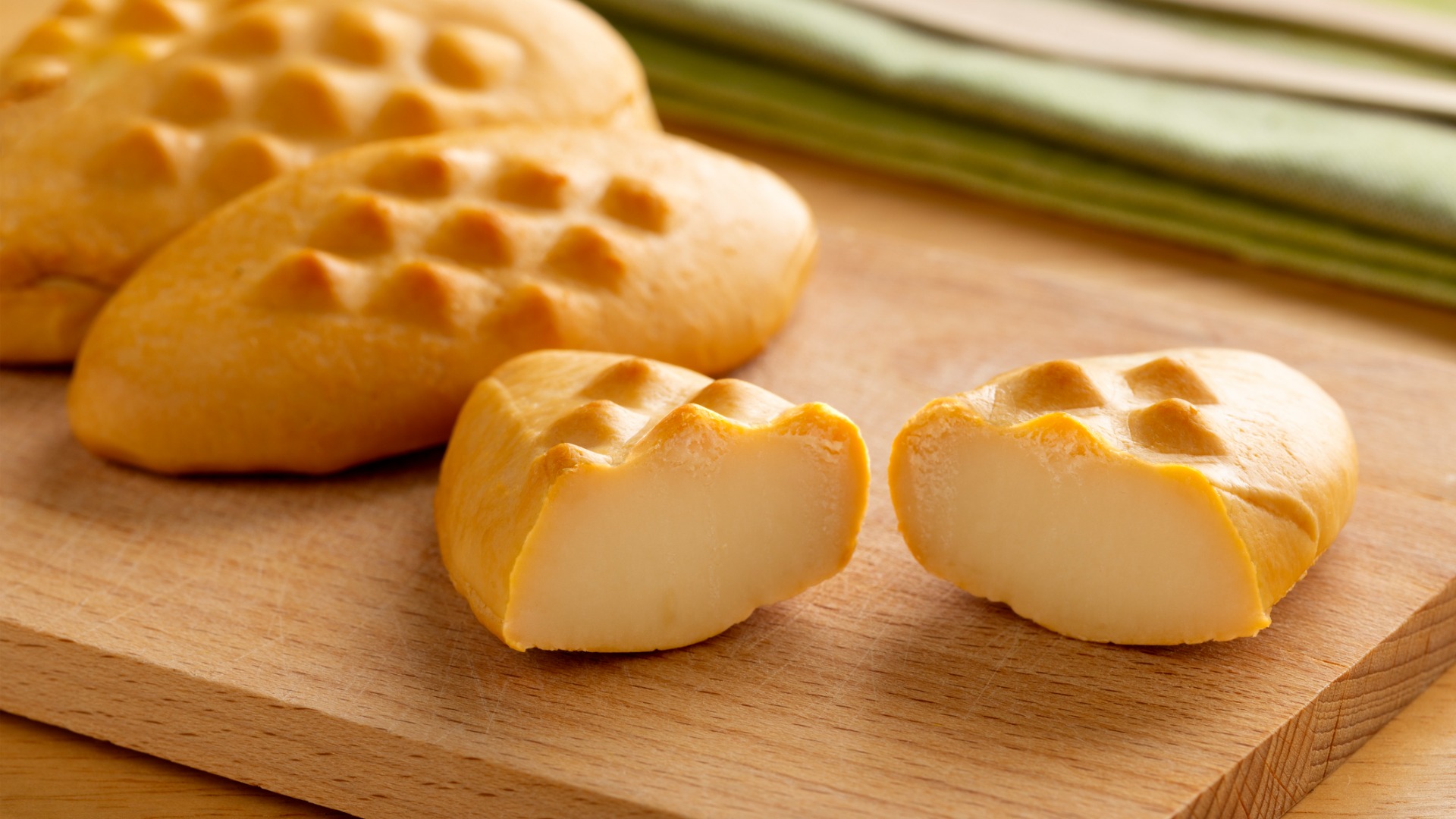 A close up of Golka cheese on a wooden cutting board. 