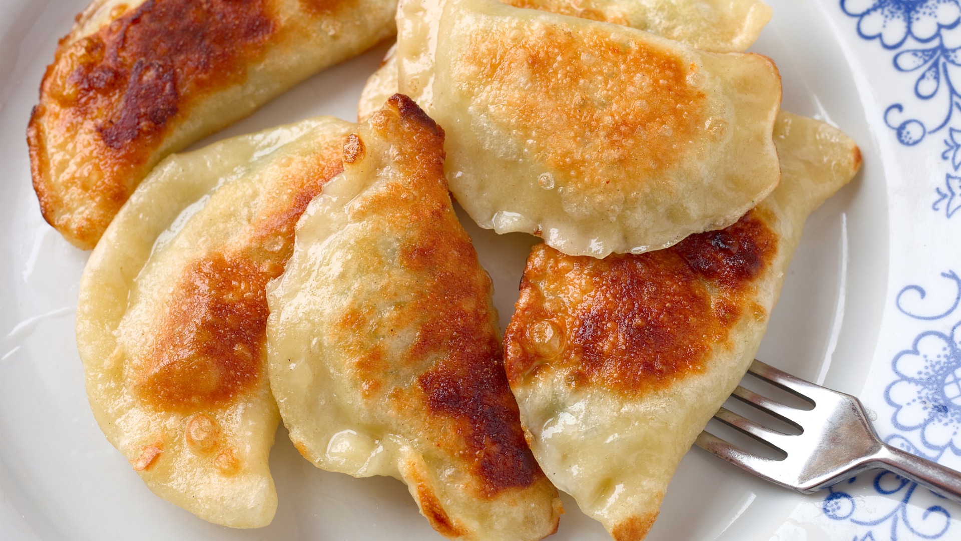 A close up of a white plate filled with Pierogi dumplings, the dish that tops our list of the best Polish food. 