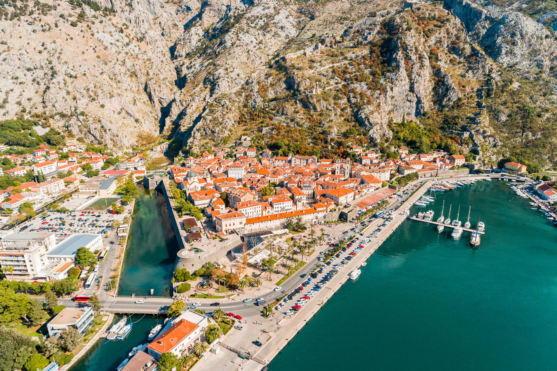 An aerial view of Kotor with its red rooftops and the tall mountains in the background. 