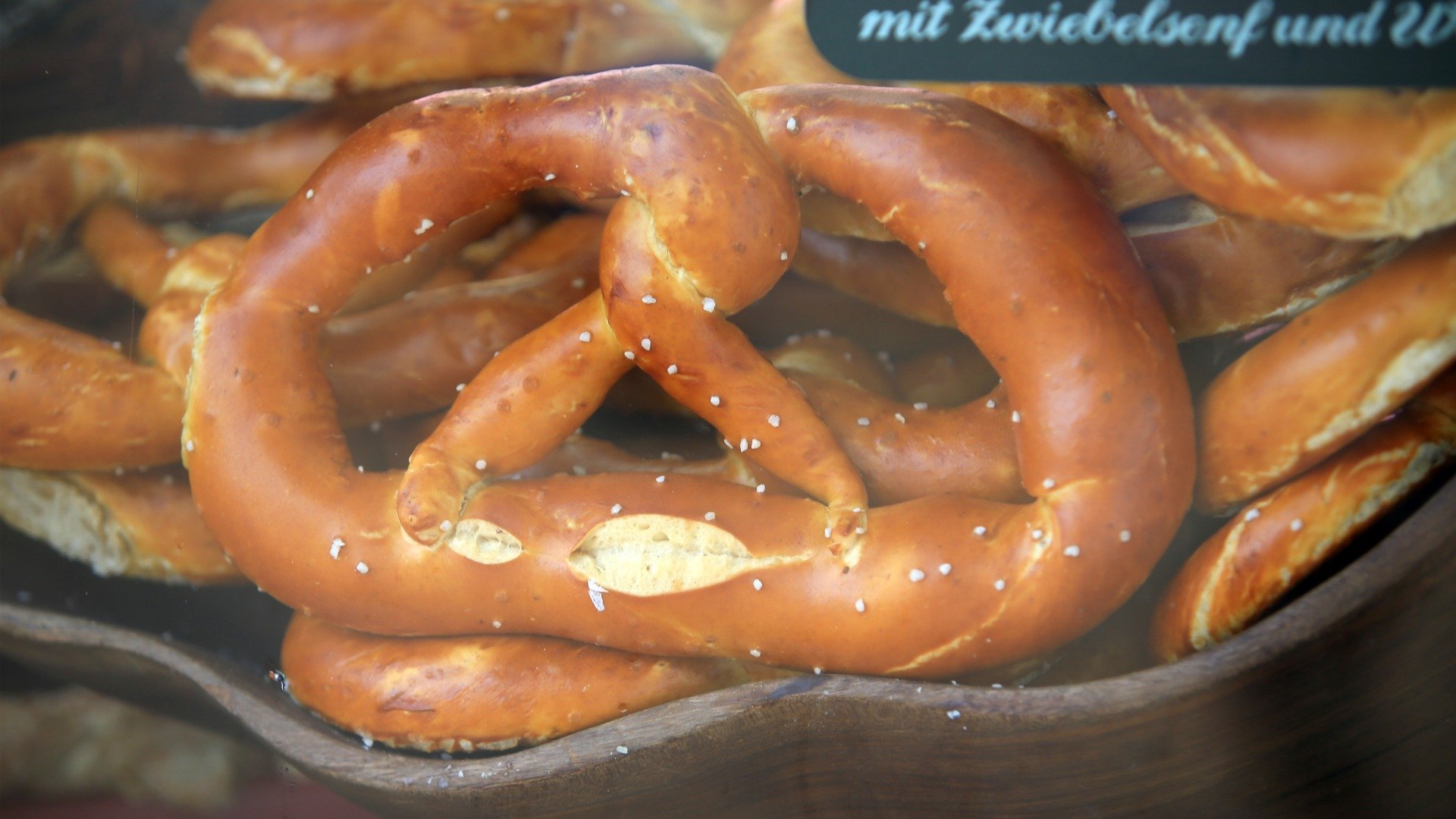 A close up of pretzels at a bakery display. 