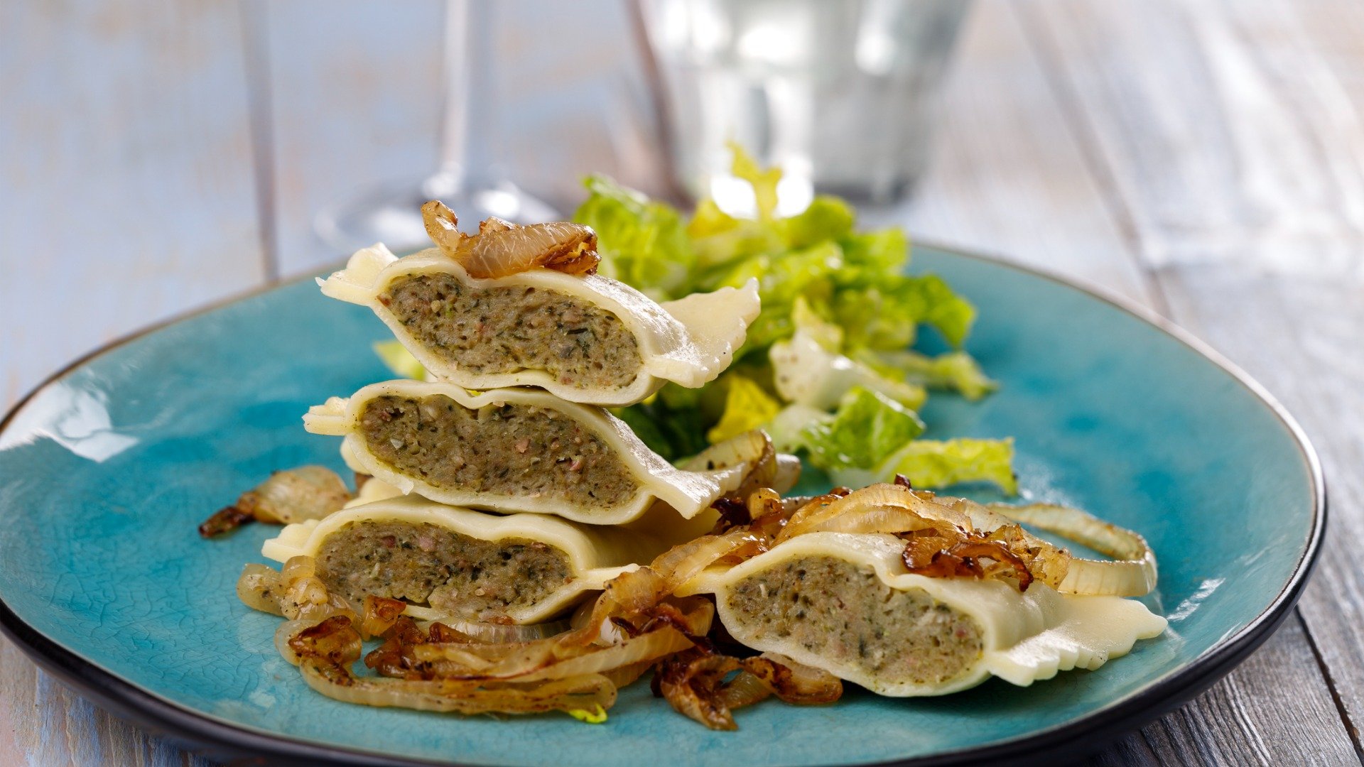 A blue plate with Maultaschen halves. 